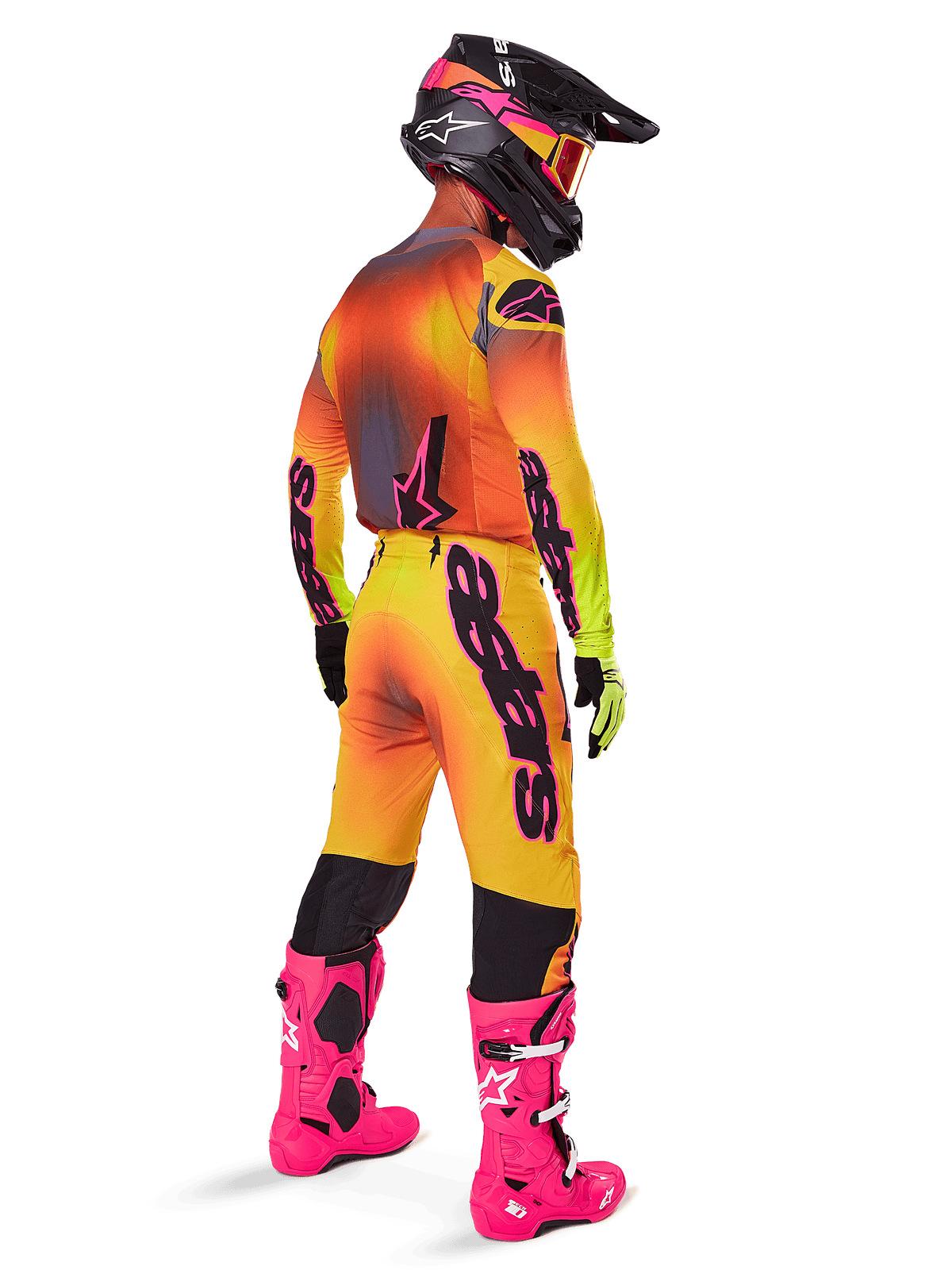 Motorcrossrijder vanaf de achterkant gezien, gekleed in Alpinestars 2025 Supertech Lipan crossbroek met een geel en roze kleurverloop, bijpassende jersey, felroze laarzen en een zwarte helm met roze accenten, professionele gecoördineerde outfit voor off-road racen.