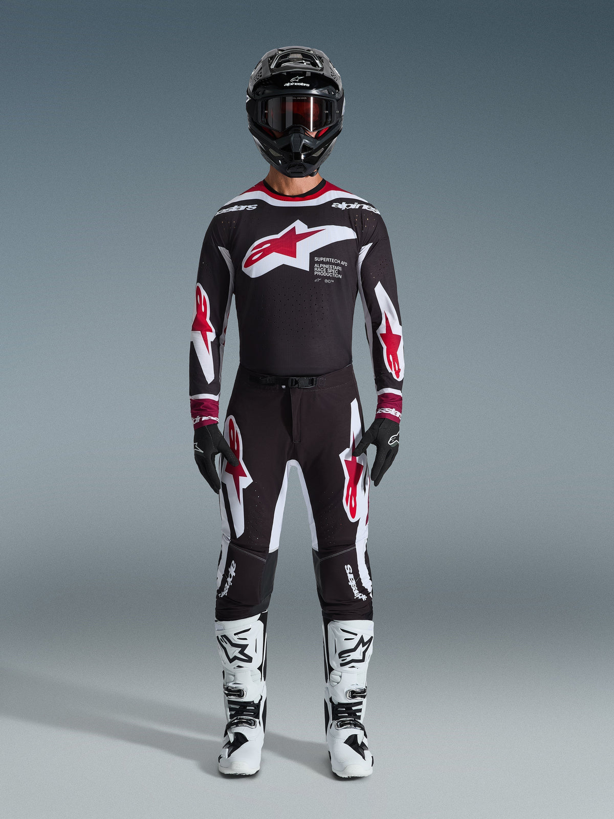 Alpinestars 2026 Supertech AFD Vista Pants, Motocross Pants, Black Red and White, worn as a complete racing gear set with matching jersey, black helmet, and white boots, featuring bold red and white Astars branding on the chest and legs, designed for elite off-road performance