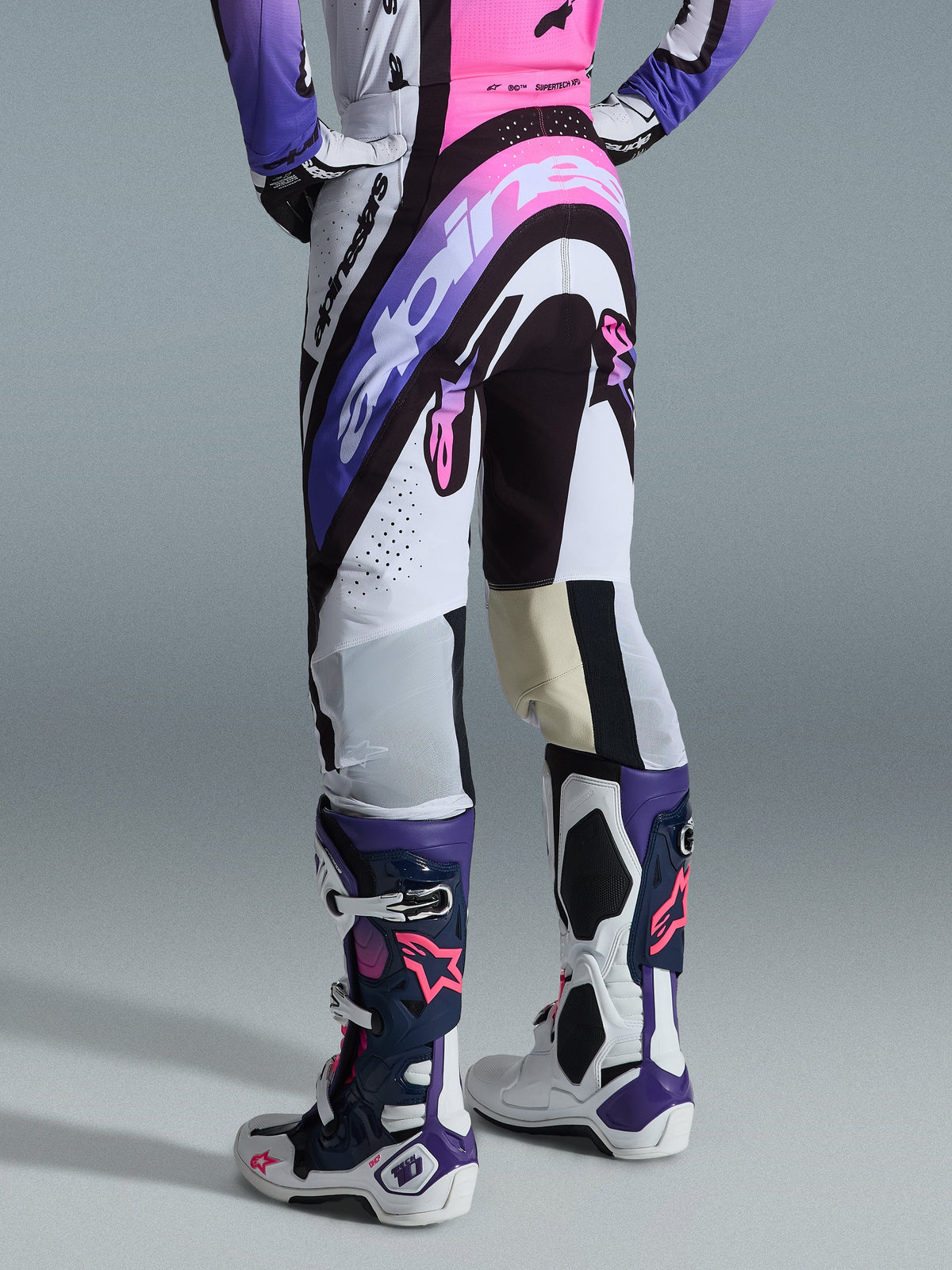 Alpinestars 2026 Supertech AFD Vista Pants, Motocross Pants, White Purple and Black with pink accents, rear view worn with matching jersey and Tech 10 boots, featuring bold logo graphics and performance materials for elite off-road racing.