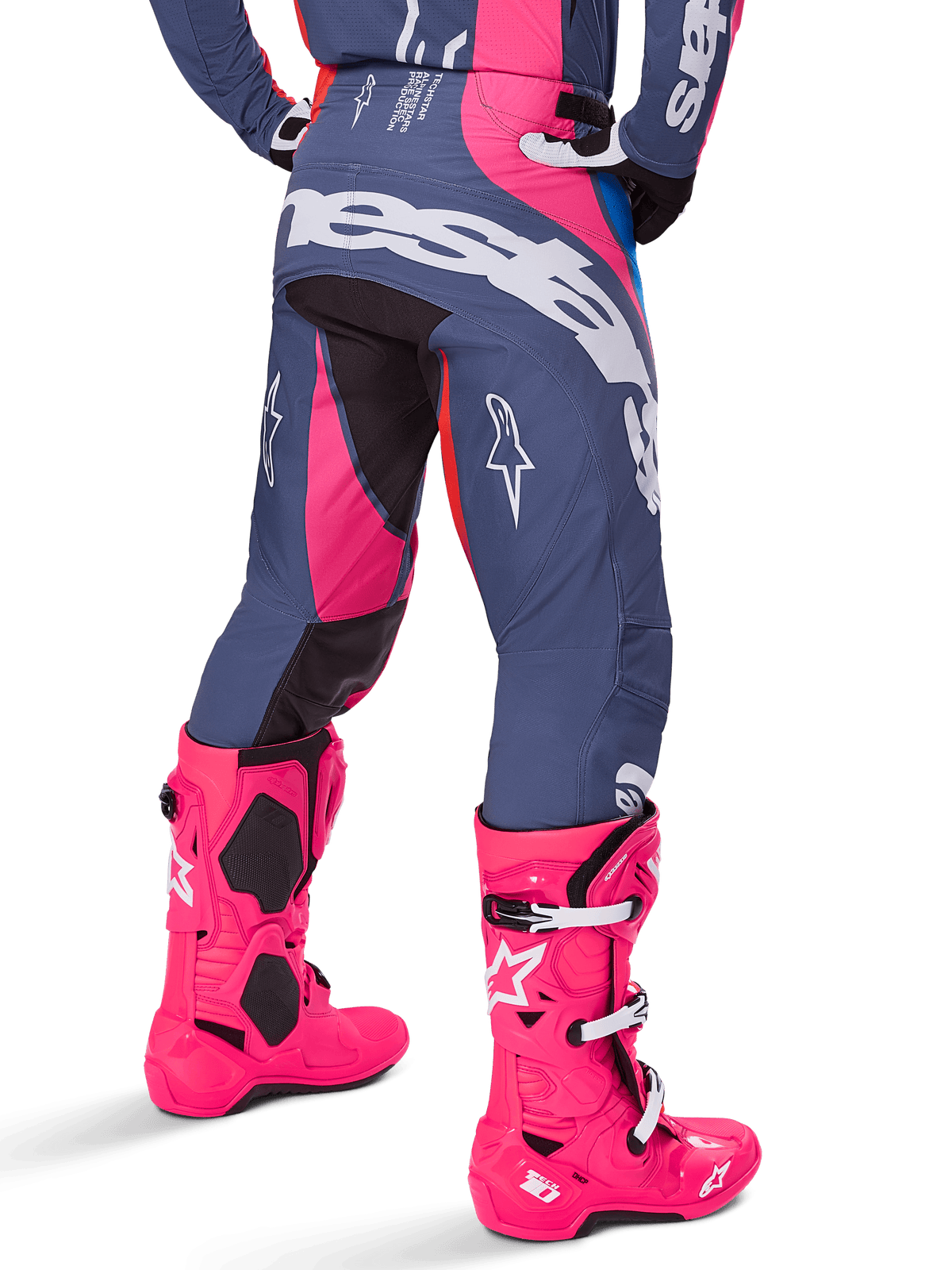 Alpinestars 2025 Techstar Dreem Hose, Motocross-Hose, Grau und Pink mehrfarbig, Rückansicht mit großem weißem Alpinestars-Branding auf dem Gesäß, getragen mit passenden leuchtend pinken Tech 10 Stiefeln, strapazierfähige Offroad-Rennausrüstung mit verstärkten Einsätzen.