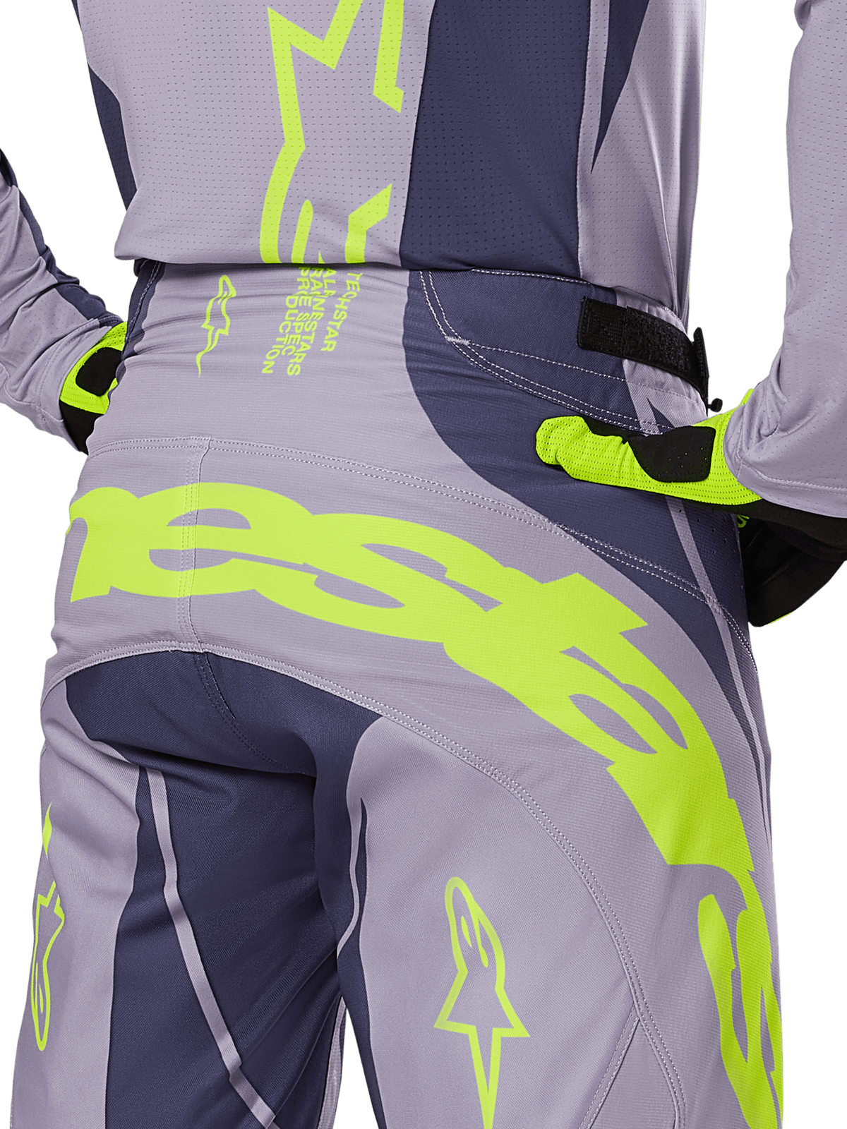 Alpinestars 2025 Techstar Dreem Hose, Motocross-Hose, Grau und Dunkelgrau mit leuchtend limonengrünen Akzenten, Rückansicht im Detail mit passendem Trikot und Handschuhen, großes neongelbes Branding am Gesäß, athletische Rennpassform für den Offroad-Sport
