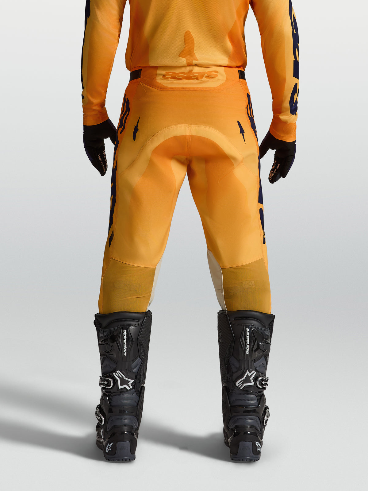 Alpinestars Racer Amber, pantalon de motocross pour homme, orange et bleu foncé, vue de dos avec assise renforcée et inserts extensibles, conçu pour le pilotage tout-terrain