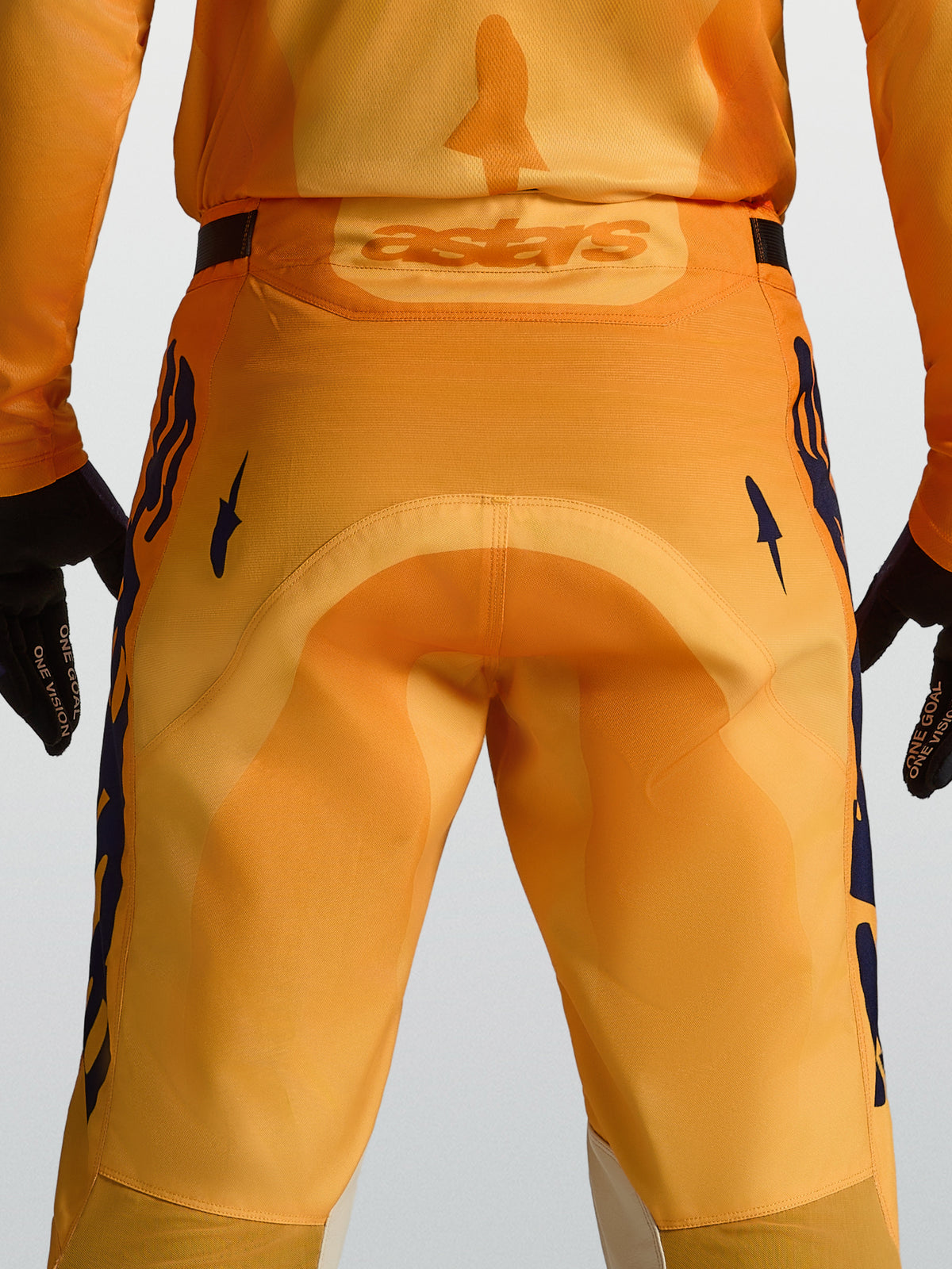 Pantalon Alpinestars Racer Amber, pantalon de motocross pour homme, orange et bleu foncé, siège renforcé et logo Astars au dos.