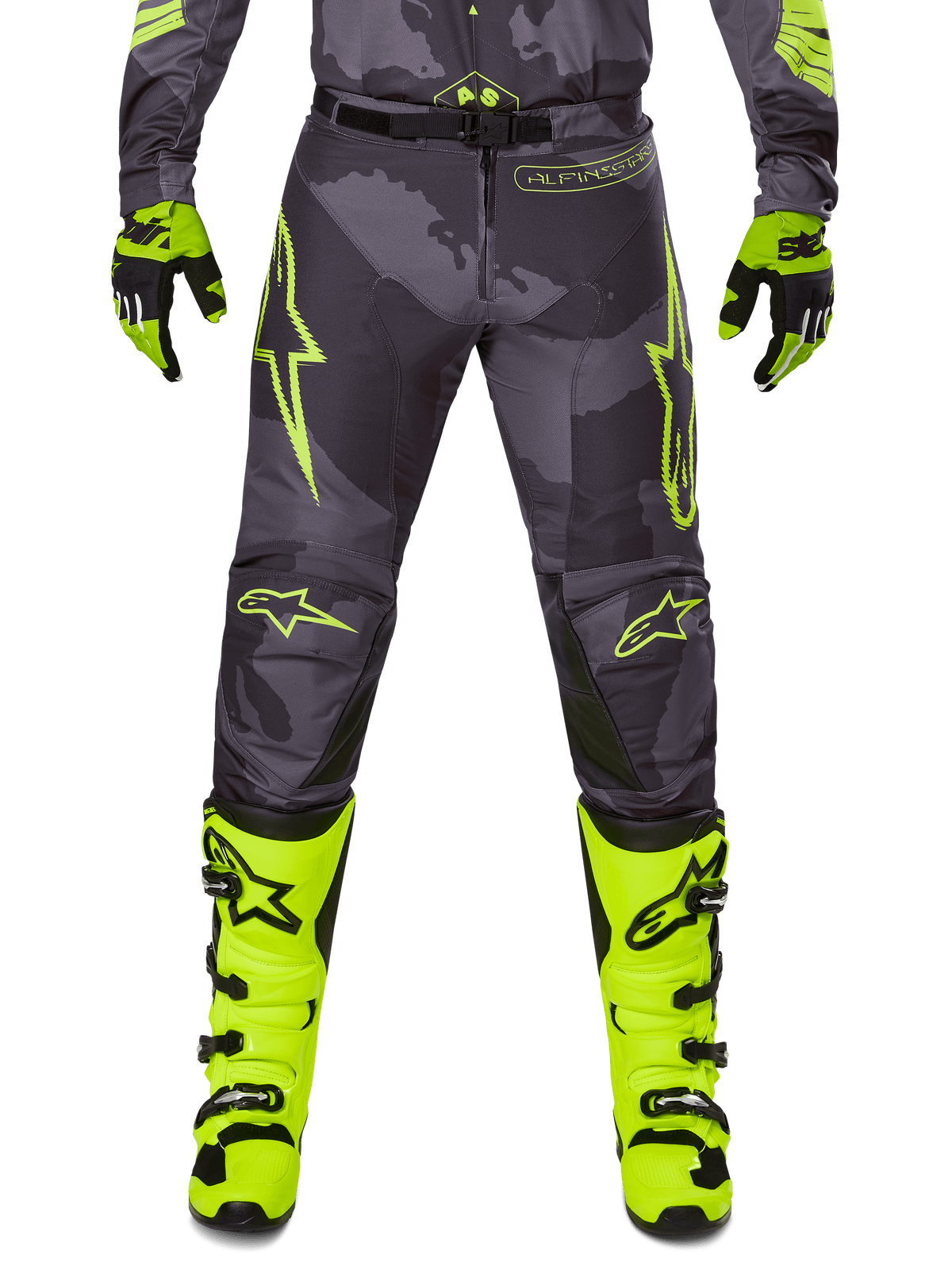Alpinestars 2025 Racer Hollow Hose, Motocross-Hose, Dunkelgrau mit Neongelb, Sterndesigns und Logo, Person trägt komplette Offroad-Schutzausrüstung mit schwarzen und neongelben Handschuhen und neongelben Stiefeln