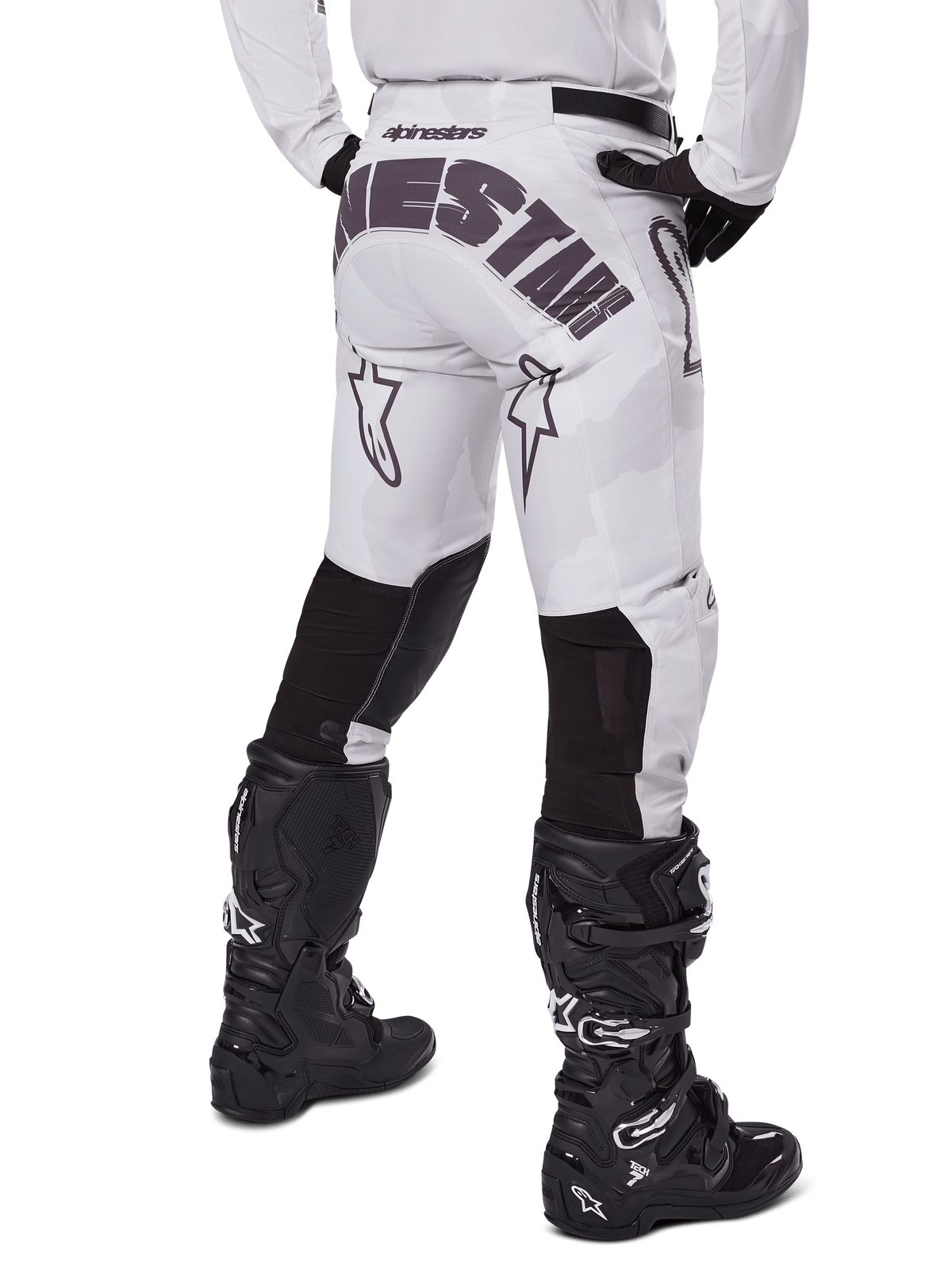 Alpinestars 2025 Racer Hollow Pants, motorcrossbroek, Light Camo Brown, achteraanzicht van de rijder met grote branding op het zitvlak en zwarte stretchpanelen op de onderbenen, gecombineerd met zwarte Tech 7 laarzen