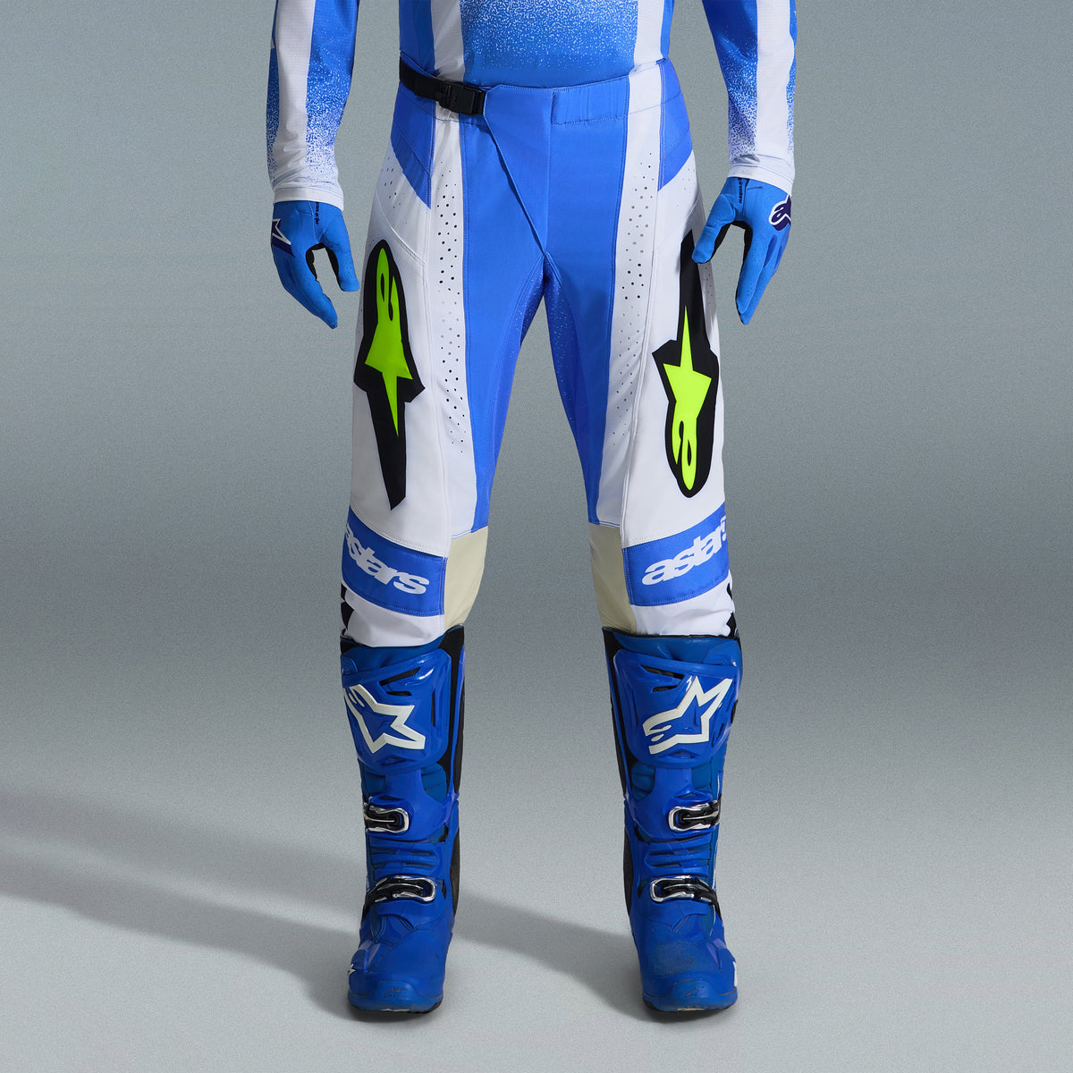 Alpinestars 2026 Techstar Knif Gear Set, blau-weiße Motocross-Hose mit neongelben Logos, passende blaue Stiefel und Handschuhe, professionelles sportliches Rennoutfit für den Offroad-Wettbewerb