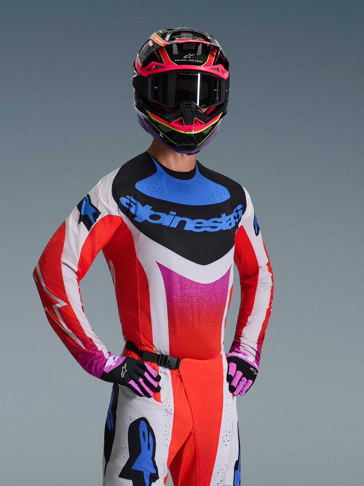 Maillot Alpinestars Techstar Knif 2026, maillot de motocross, blanc avec des motifs en dégradé rouge, bleu et rose, arborant un logo bleu sur la poitrine, porté avec un casque et des gants coordonnés, design de course athlétique pour la performance tout-terrain