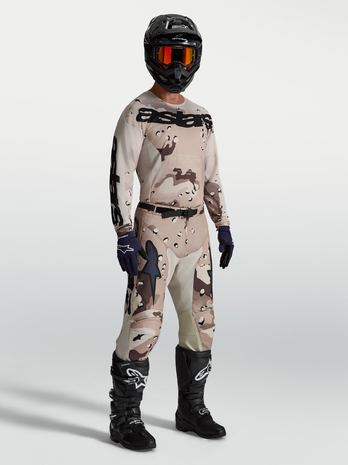 Alpinestars Racer Lone Gear Set, motorcross-set in tan en bruine camouflage met zwarte motorlaarzen voor off-road prestaties.