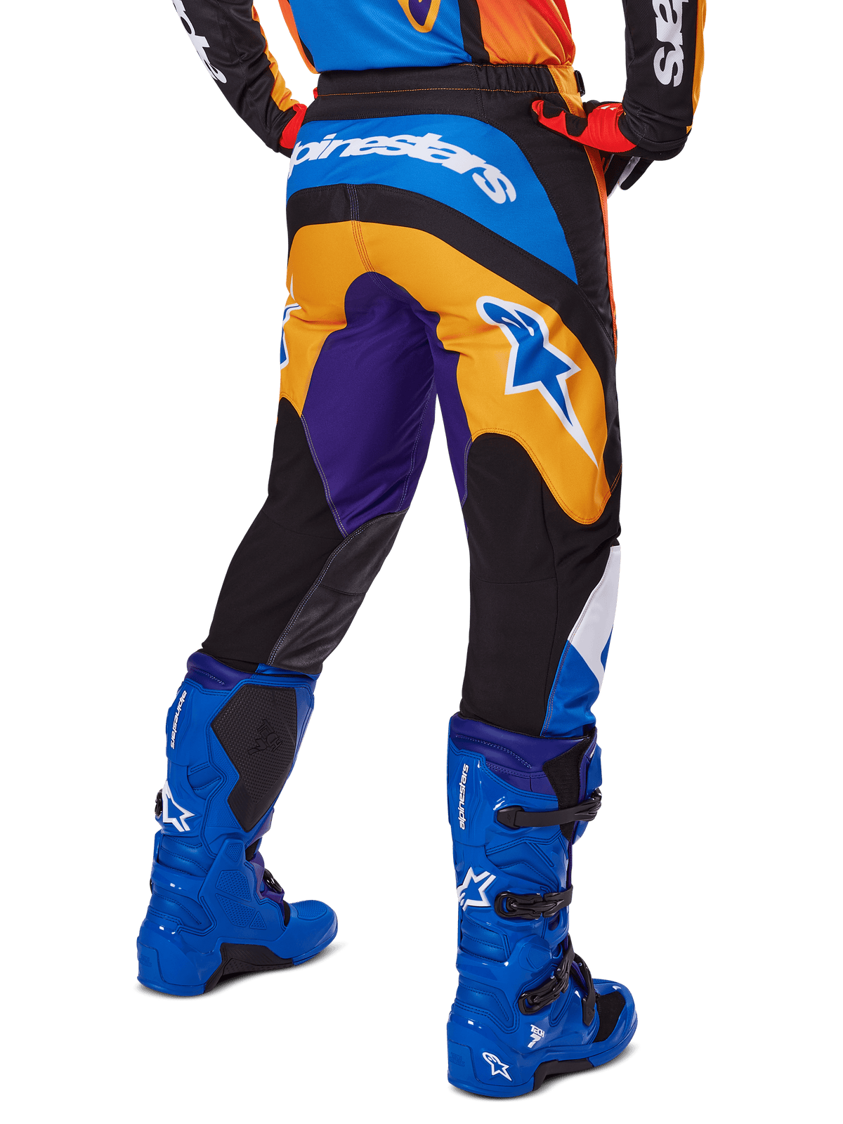 Alpinestars 2025 Fluid Wurx Hose, Motocross-Hose, Mehrfarbig mit Orange, Lila und Blau, Rückansicht mit weißem Alpinestars-Logo auf der Rückseite, kombiniert mit blauen Motocross-Stiefeln, sportliche Passform für Offroad-Rennsport