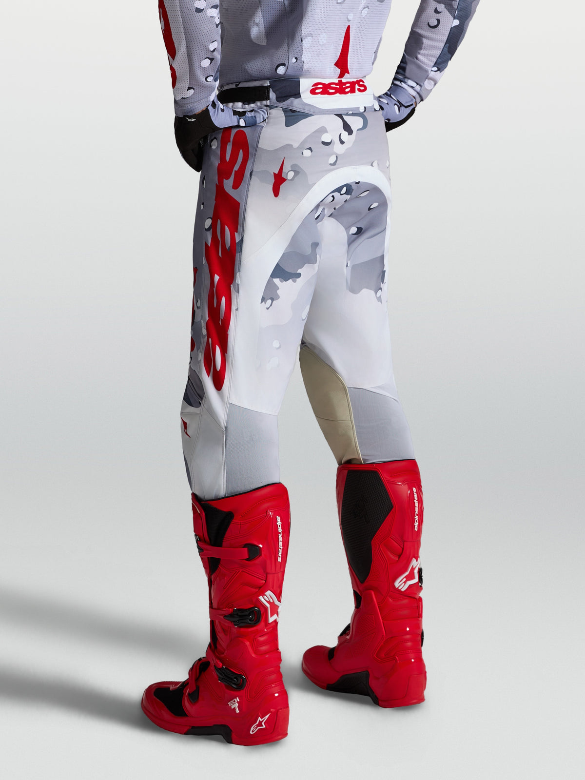 Alpinestars Racer Air Lone broek, motorcrossbroek in grijs camouflage en wit met rode accenten, achterzijde op model.