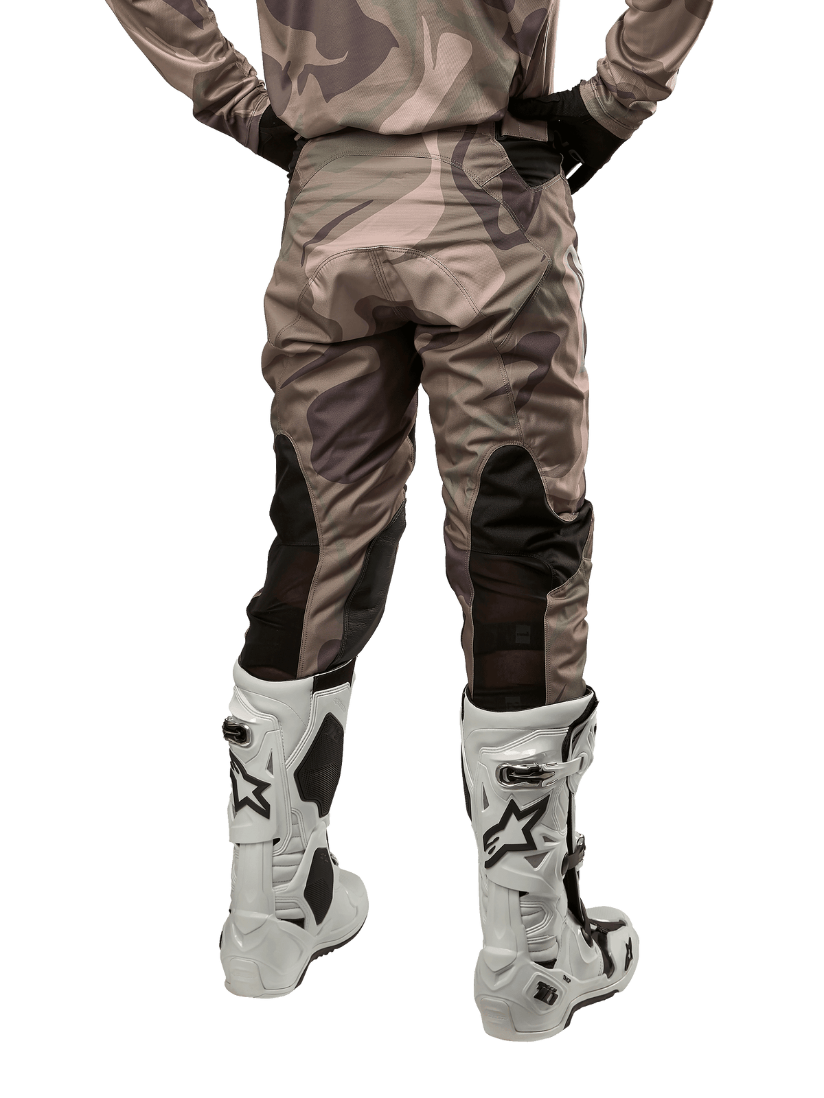 Alpinestars 2024 Racer Tactical crossbroek, motorcross broek, legergroen camouflage bruin, achteraanzicht met camouflagepatroon en zwarte ademende stretchpanelen op de onderbenen, gedragen met witte motorcrosslaarzen, duurzame technische uitrusting voor off-road rijden