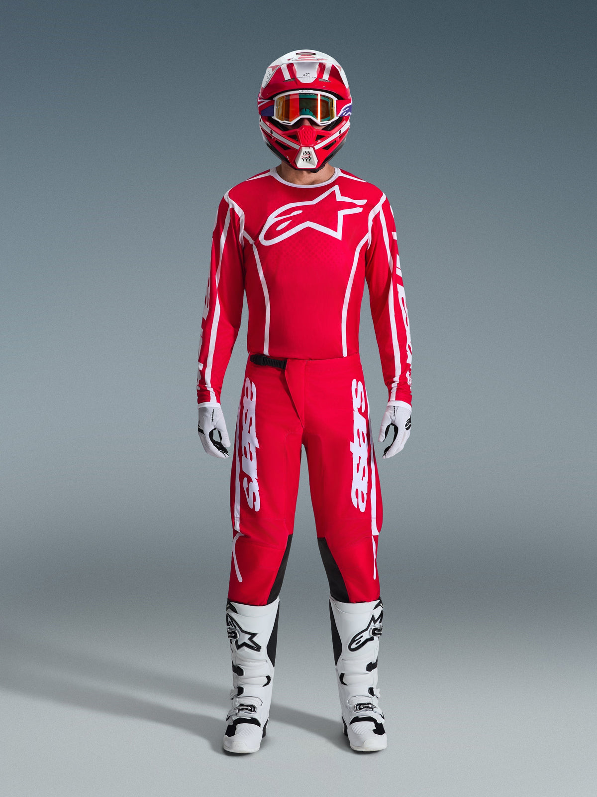 Alpinestars 2026 Fluid Apex Hose, Motocross-Hose, Rot und Weiß, getragen als komplettes Rennausrüstungs-Set mit passendem rotem Jersey, weißen Stiefeln und rot-weißem Helm, mit markantem Branding und schwarzen Einsätzen für Offroad-Performance.