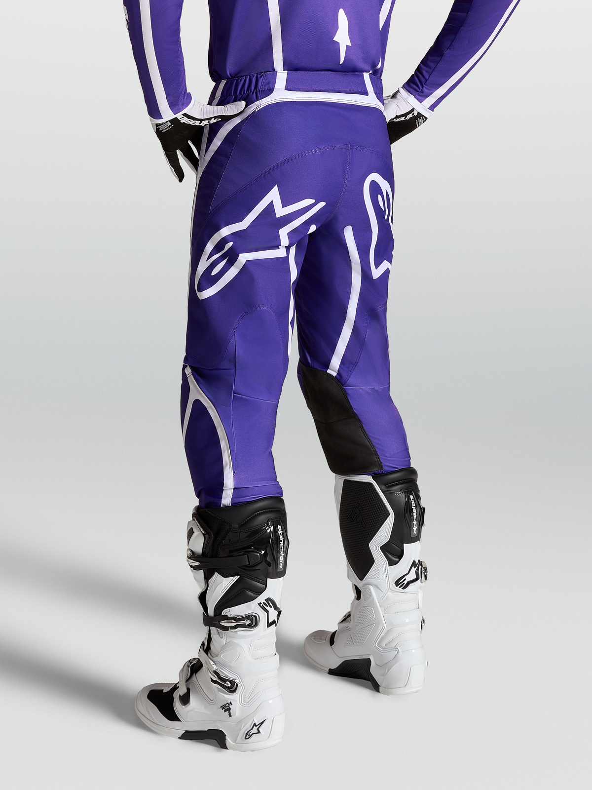 Alpinestars Fluid Apex V2, pantalon de motocross pour homme, bleu foncé et blanc, vue de dos montrant le logo étoile et la coupe ergonomique 3D.