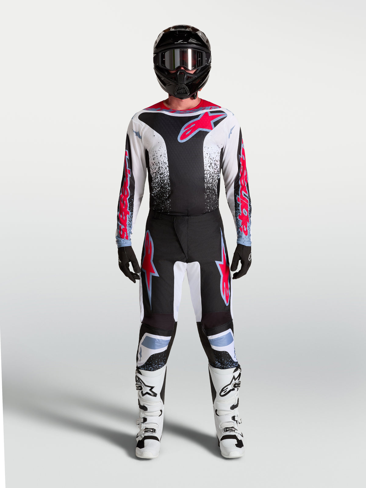 Alpinestars Fluid Drag heren motocrossbroek in zwart, wit en fluo-rood met lichtblauwe accenten en ergonomische pasvorm.