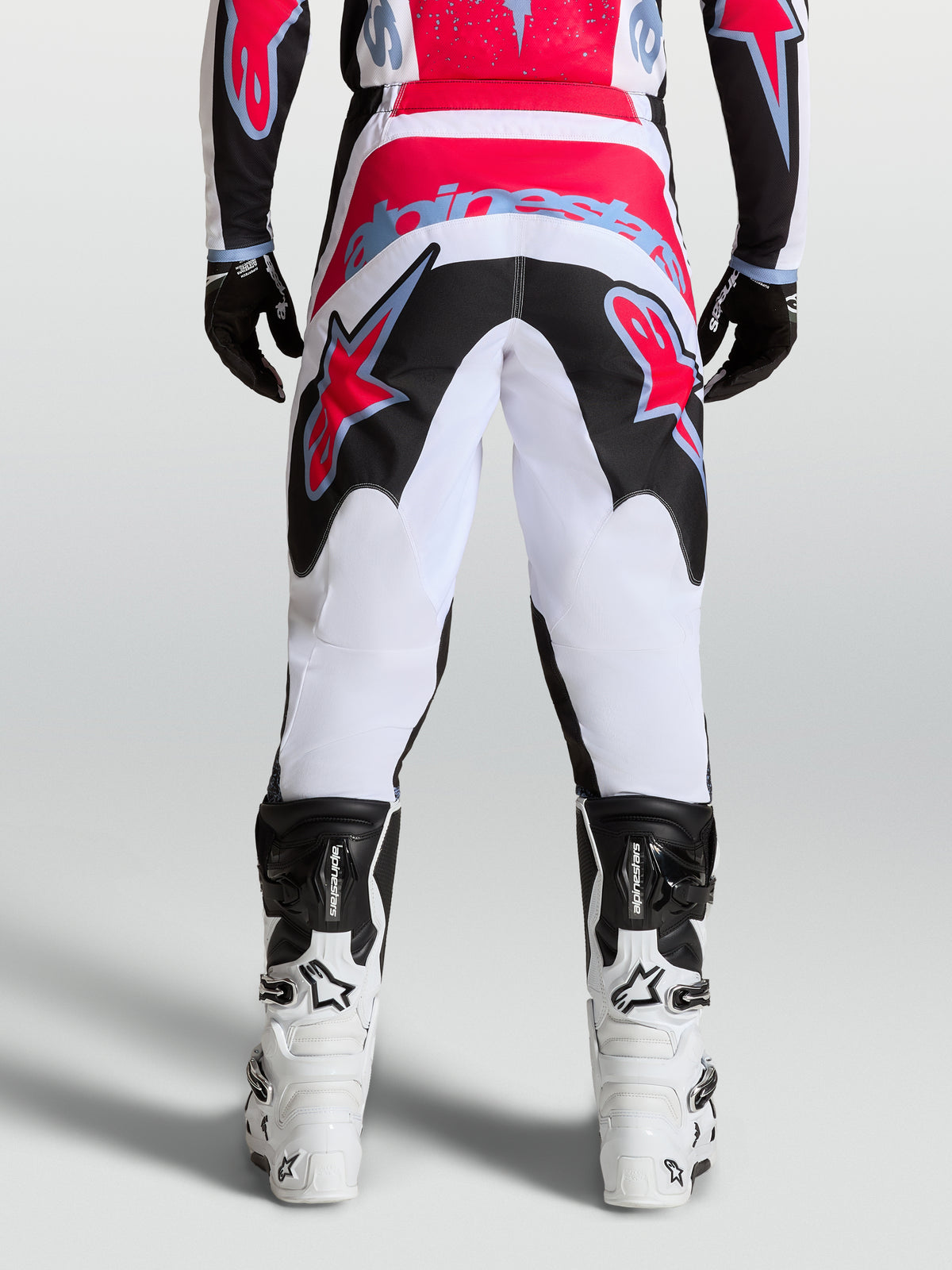 Alpinestars Fluid Drag broek, heren motorcrossbroek, wit en zwart met rode accenten, duurzame 600D polystof, achteraanzicht.