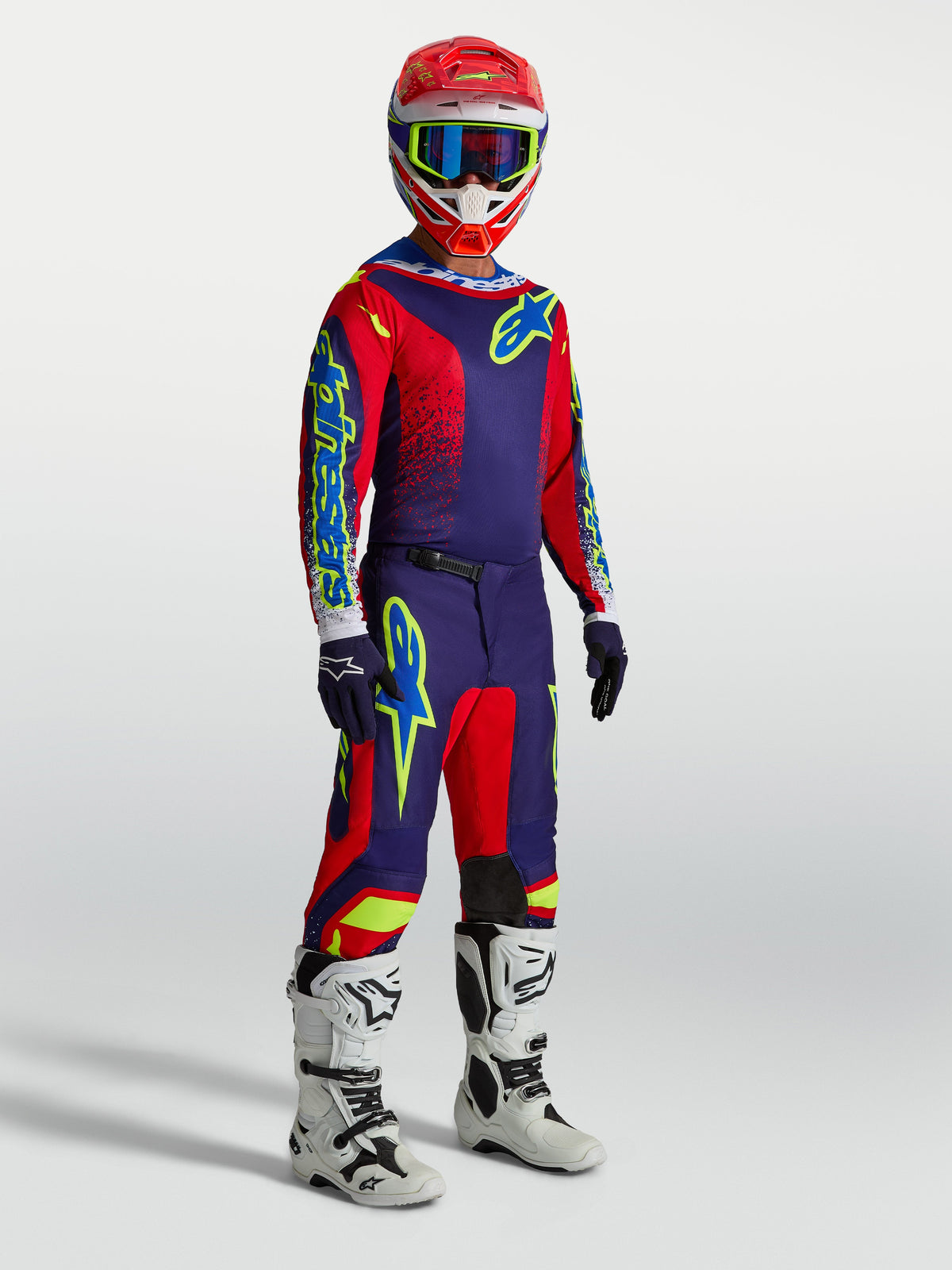 Alpinestars Fluid Drag heren-uitrustingsset, marineblauwe en rode motorcross-outfit met witte motorlaarzen.