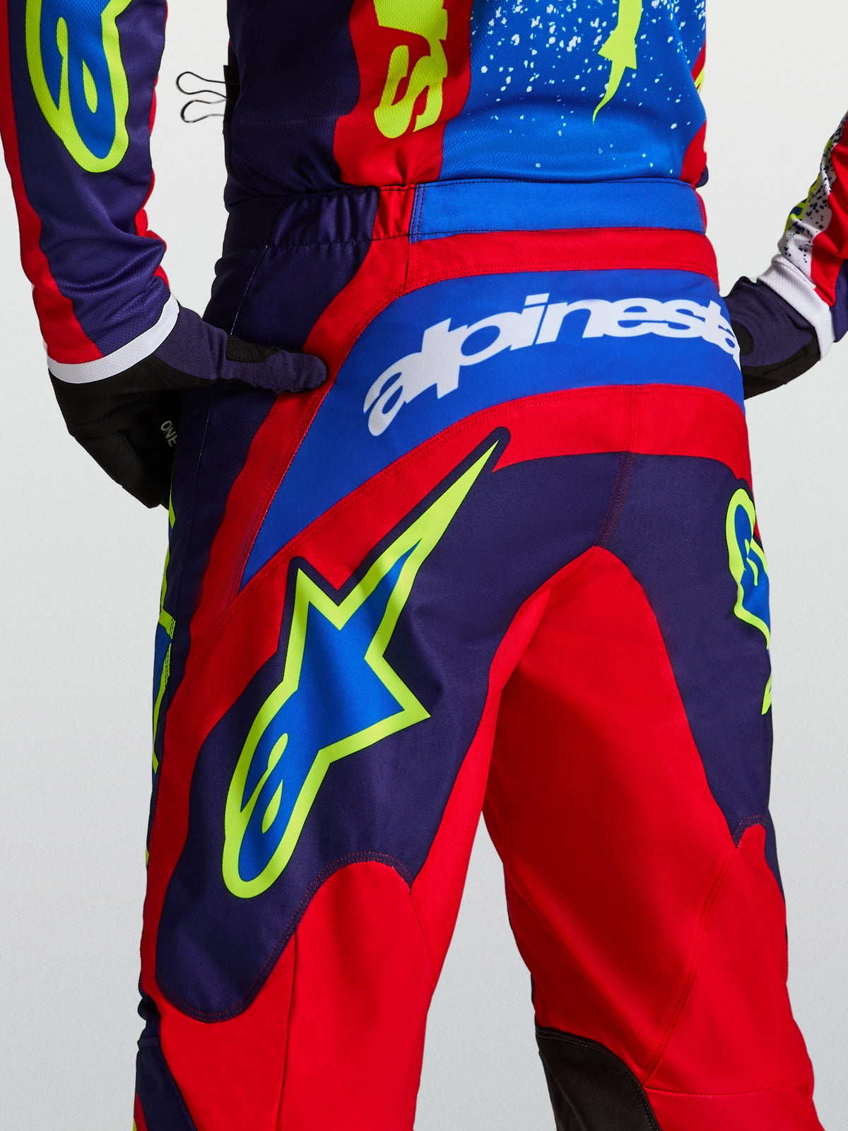 Alpinestars Fluid Drag broek, motorcrossbroek voor heren, blauw navy en rood, grote Alpinestars-branding en ster-graphics op de achterzijde, sportieve pasvorm voor off-road rijden.