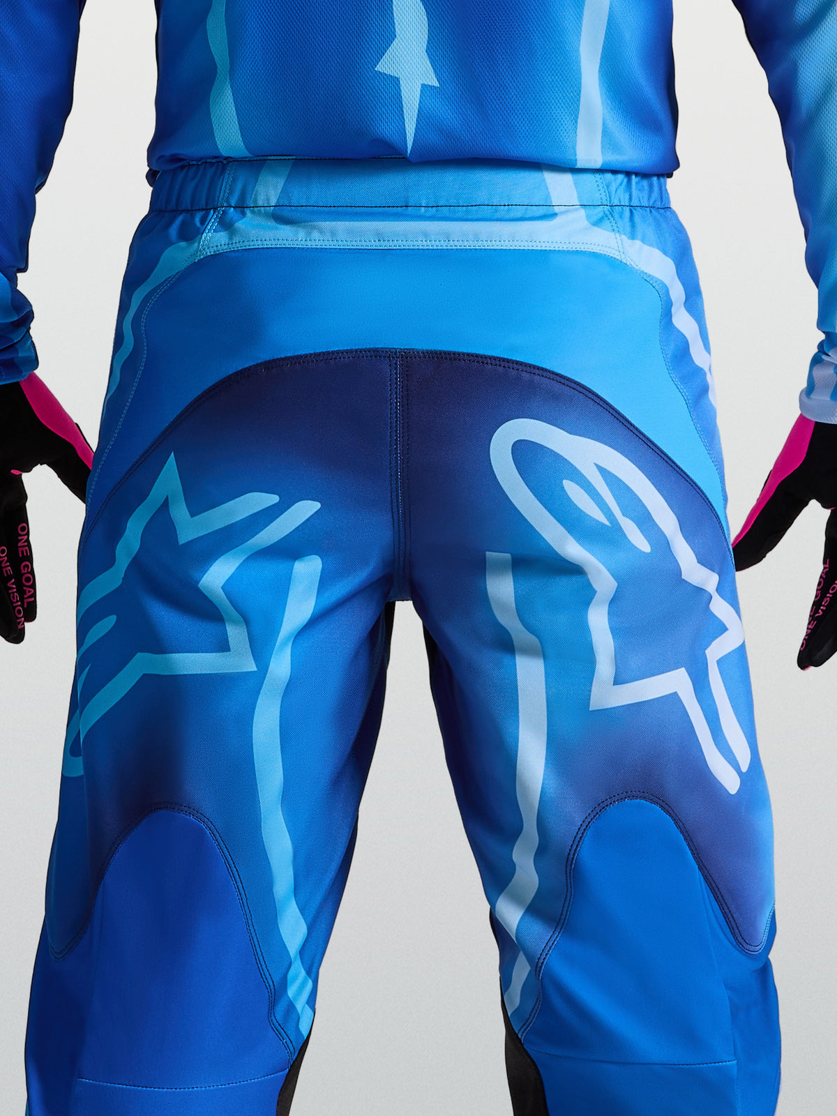 Alpinestars Pantalon Fluid Kepler, pantalon de motocross bleu pour homme, vue de dos avec de grands logos graphiques, construction en poly-tissu 600D durable pour le tout-terrain