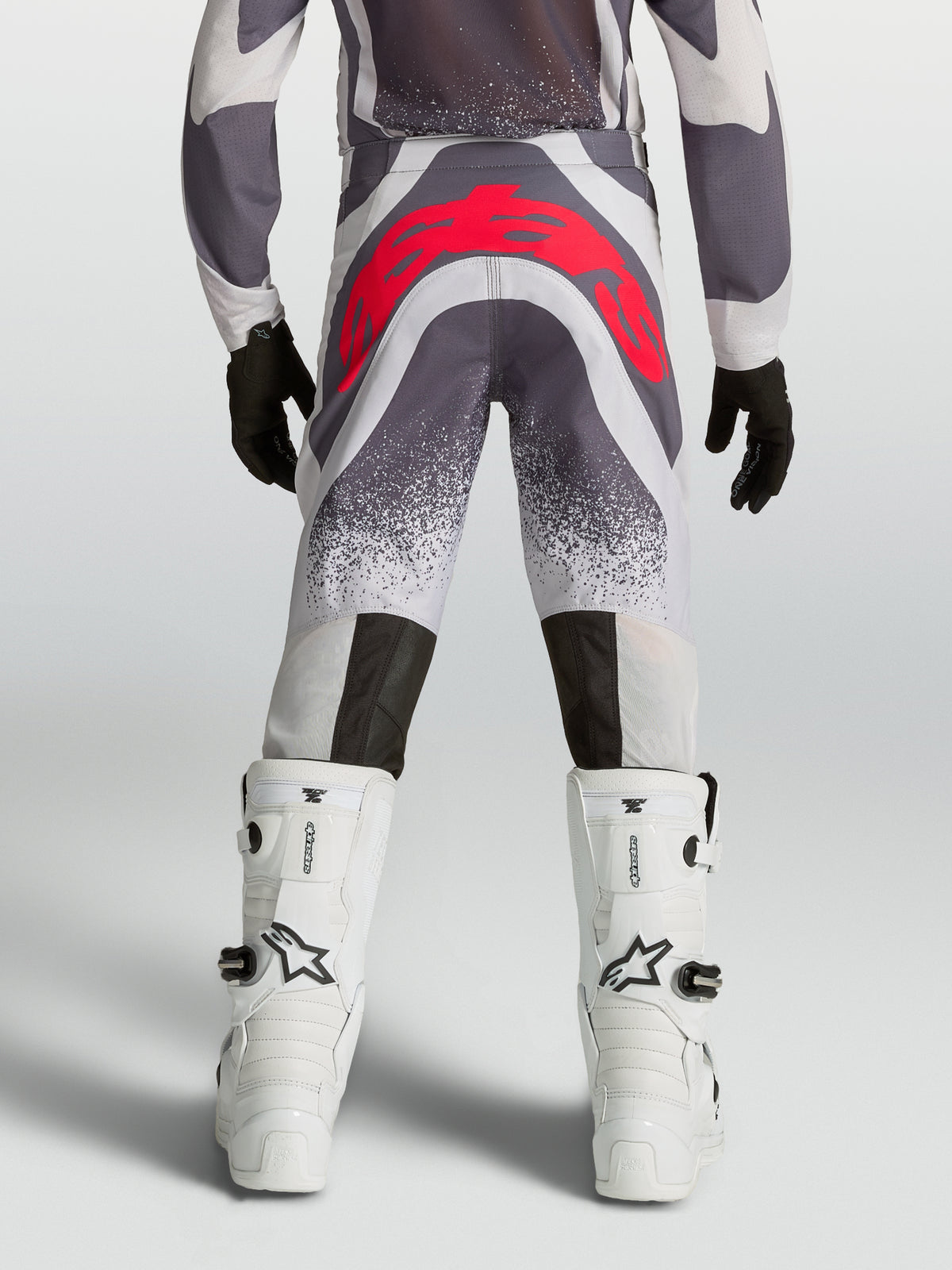 Pantalon Supertech Swan Junior Alpinestars, pantalon de motocross gris et rouge fluo, vue de dos avec assise renforcée.