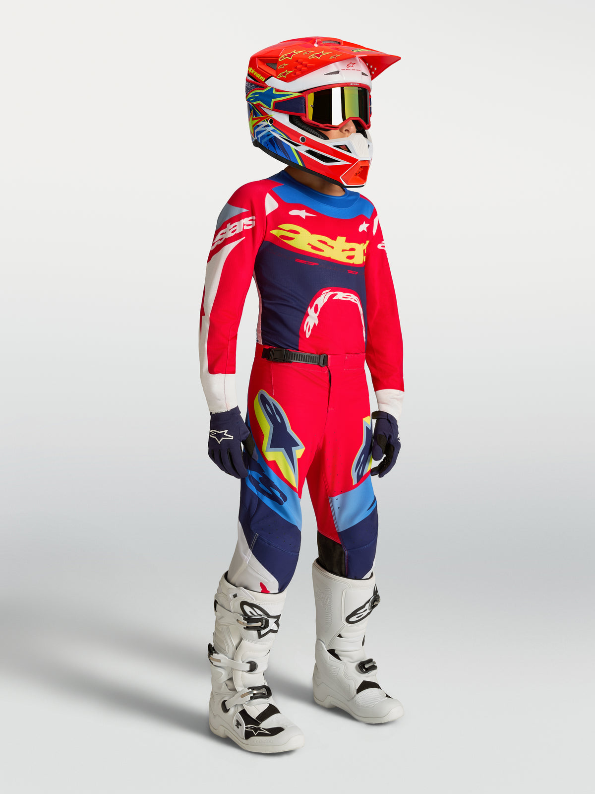 Pantalon Alpinestars Supertech Dyna Junior, motocross, rouge et bleu marine, avec maillot et casque assortis.
