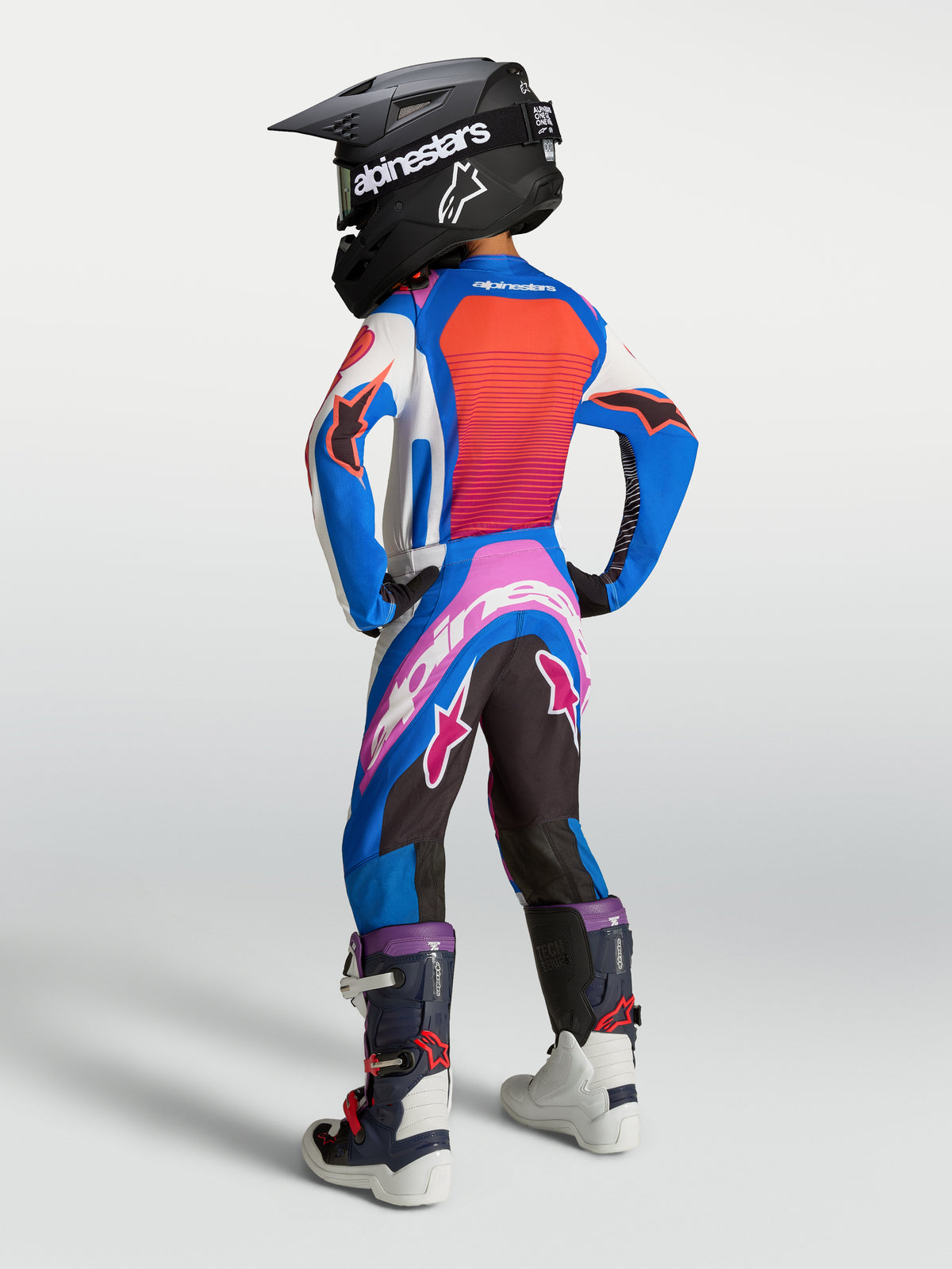 Alpinestars Youth Supertech Maven Pants, motocross racing gear in white and hot coral, seen on model from the back.