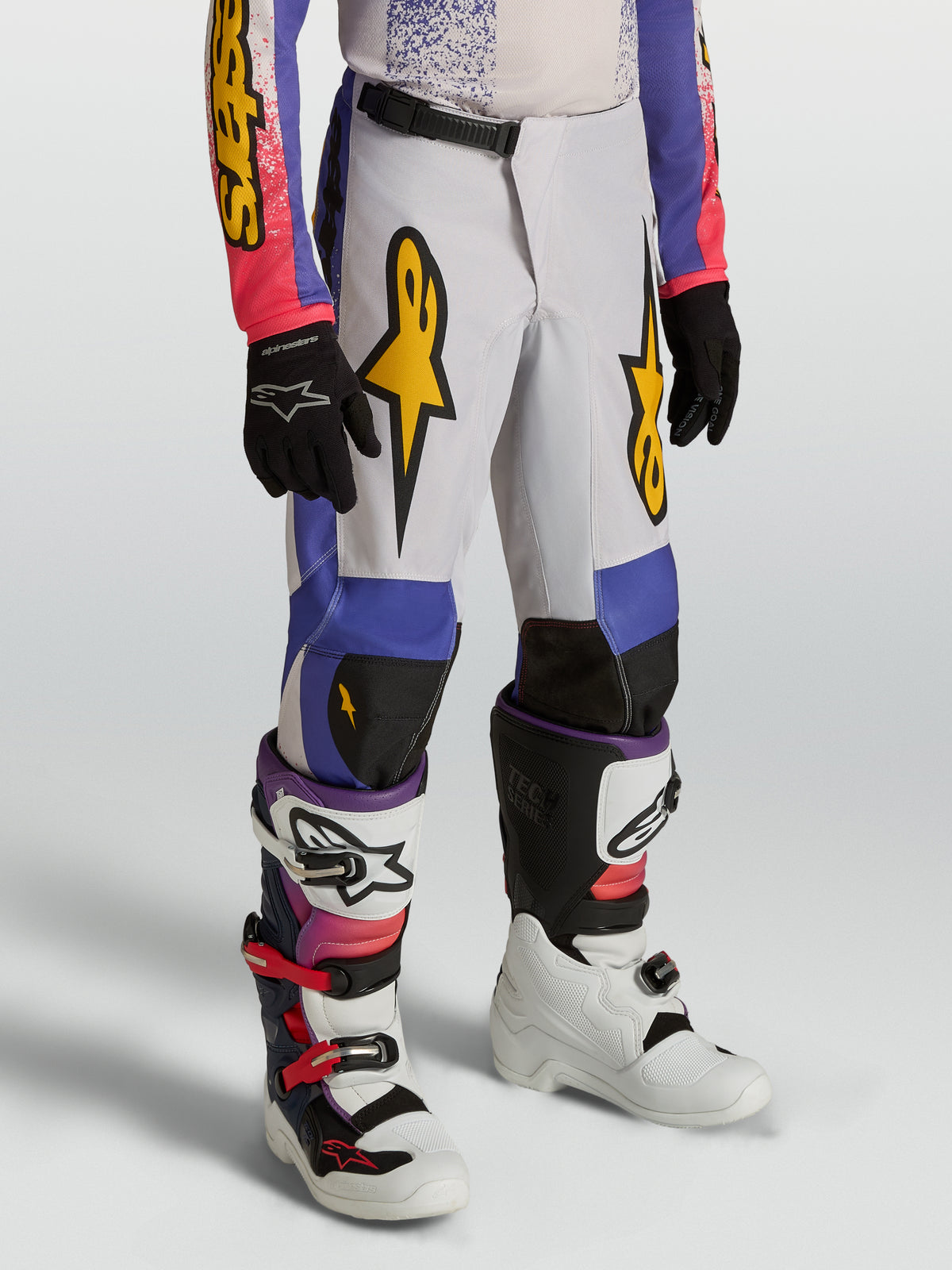 Alpinestars Jeugd Fluid Drag Broek, blauwe en paarse motocrossbroek met gouden graphics en ergonomisch voorgevormd ontwerp.