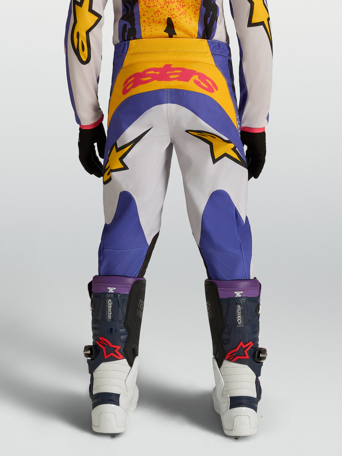 Alpinestars Jeugd Fluid Drag broek 2027, blauwe en gouden motorcrossbroek met ster-graphics, achteraanzicht, 600D constructie