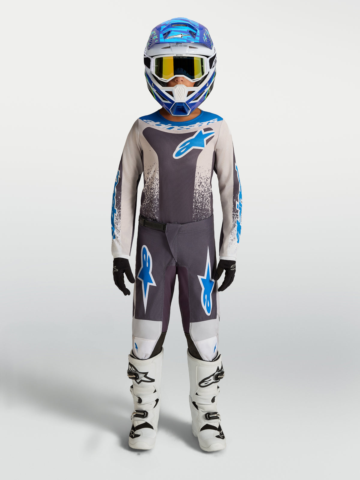 Alpinestars Youth Fluid Drag Pants, Gray and Blue Youth Motocross Gear with durable polyfabric and white boots.