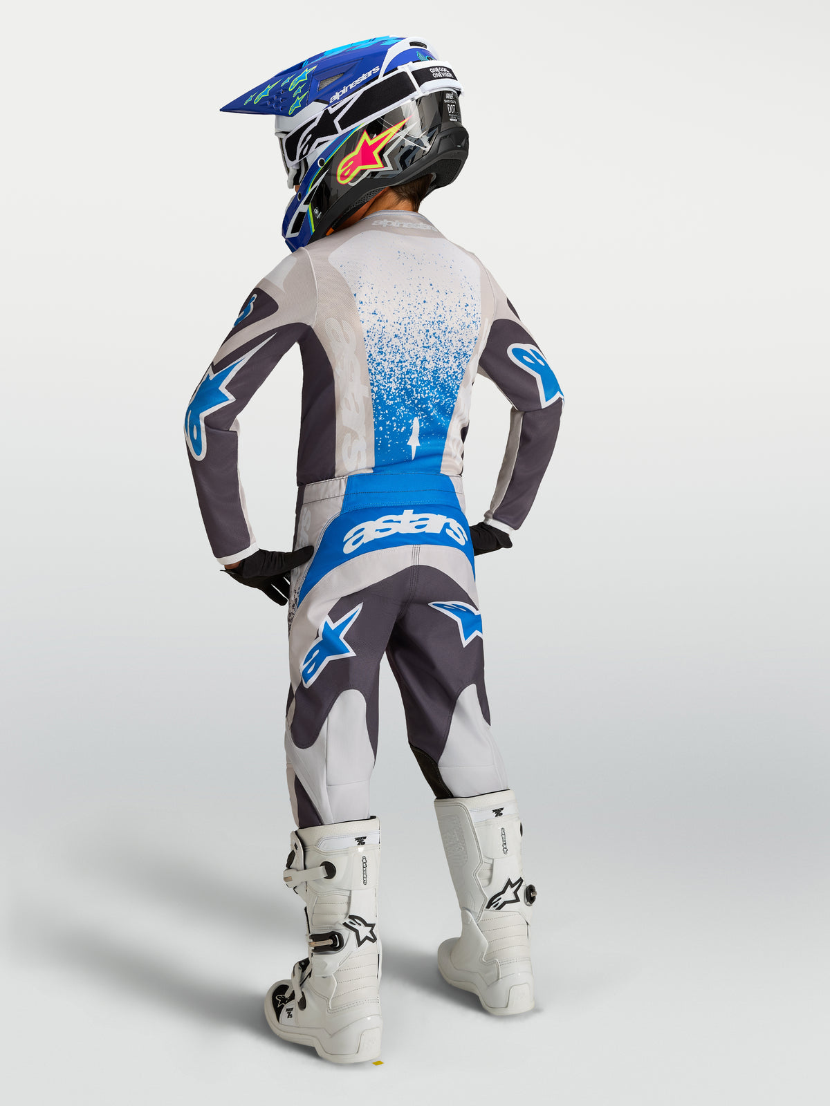 Alpinestars Youth Fluid Drag Pants, Gray and Blue Motocross Racing Gear, textile construction, rear view on young rider.