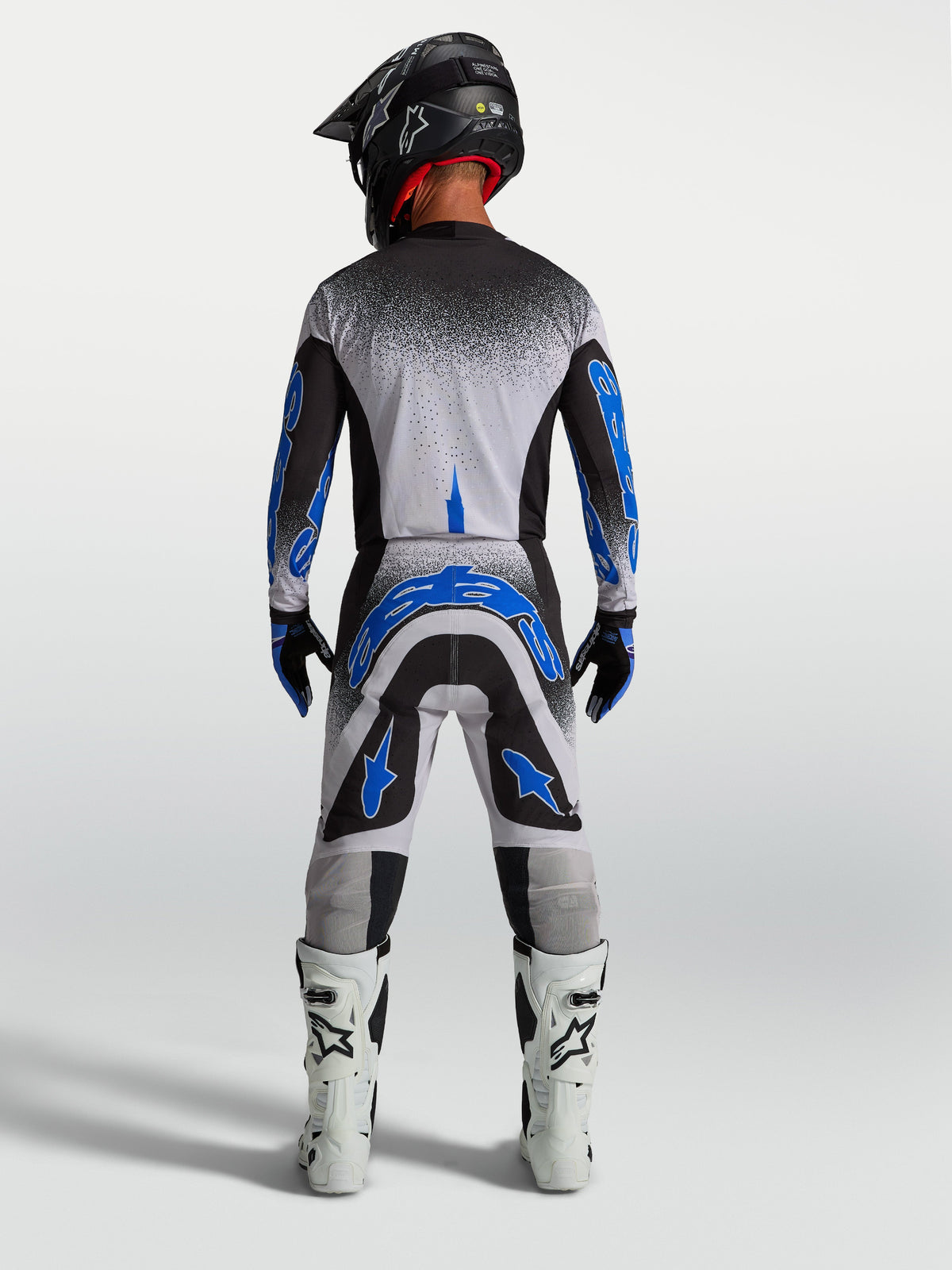 Alpinestars Supertech Hiten AFD jersey en gear set, zwart-wit-blauwe heren motocross-outfit van achteren gezien.