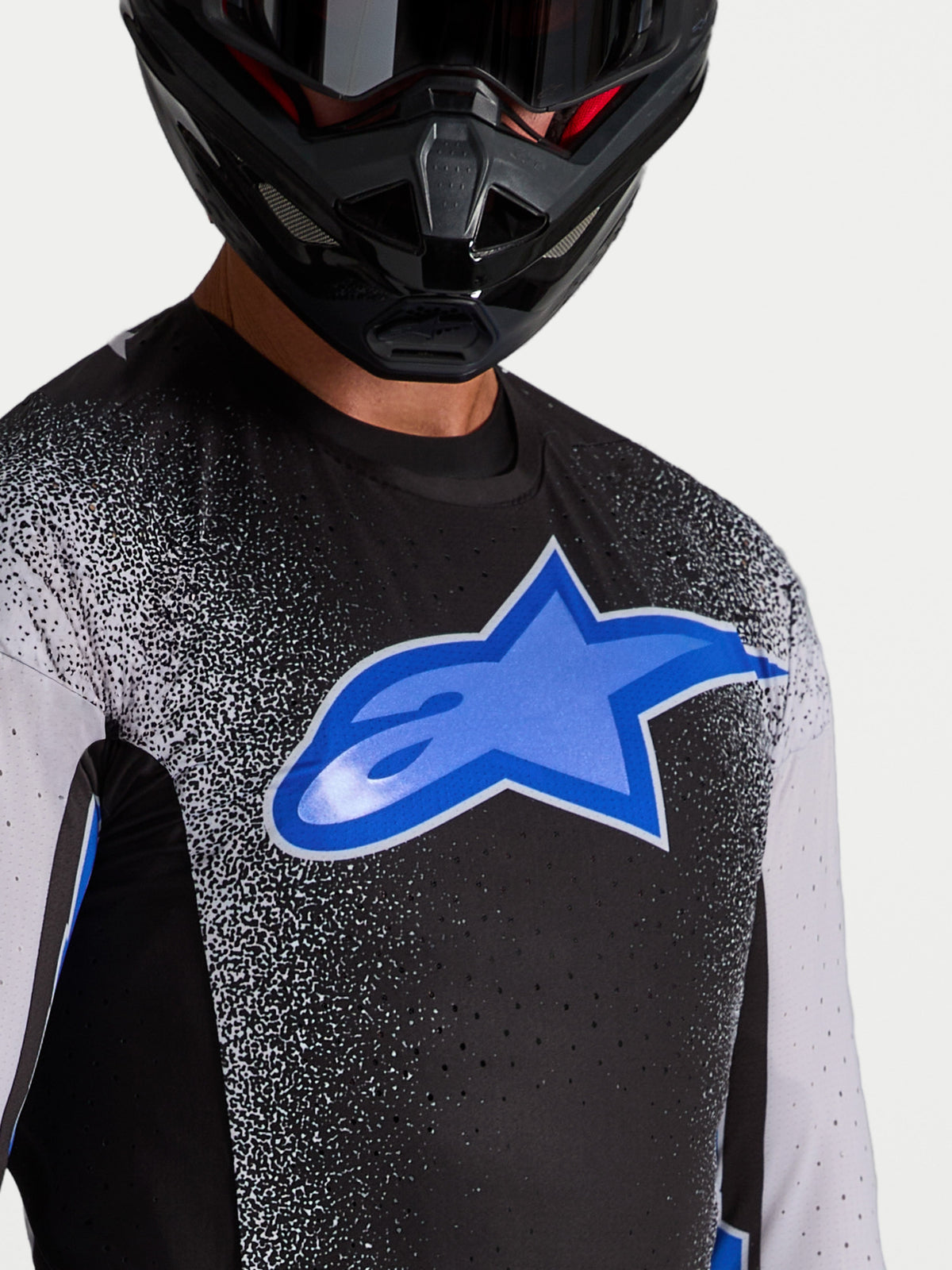 Maillot Alpinestars Supertech Hiten AFD, maillot de motocross pour homme noir et bleu avec perforations découpées au laser.