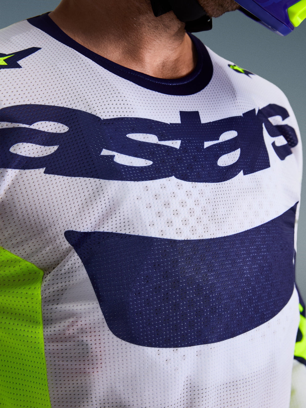Alpinestars 2026 Racer Air Riway Trikot, Motocross-Trikot, Hellgrau, Gelb Fluo und Blau, Nahaufnahme der Brust mit atmungsaktiver Mesh-Luftstromkonstruktion und dunkelblauem Astars-Logo, entwickelt für High-Performance-Offroad-Fahrten.