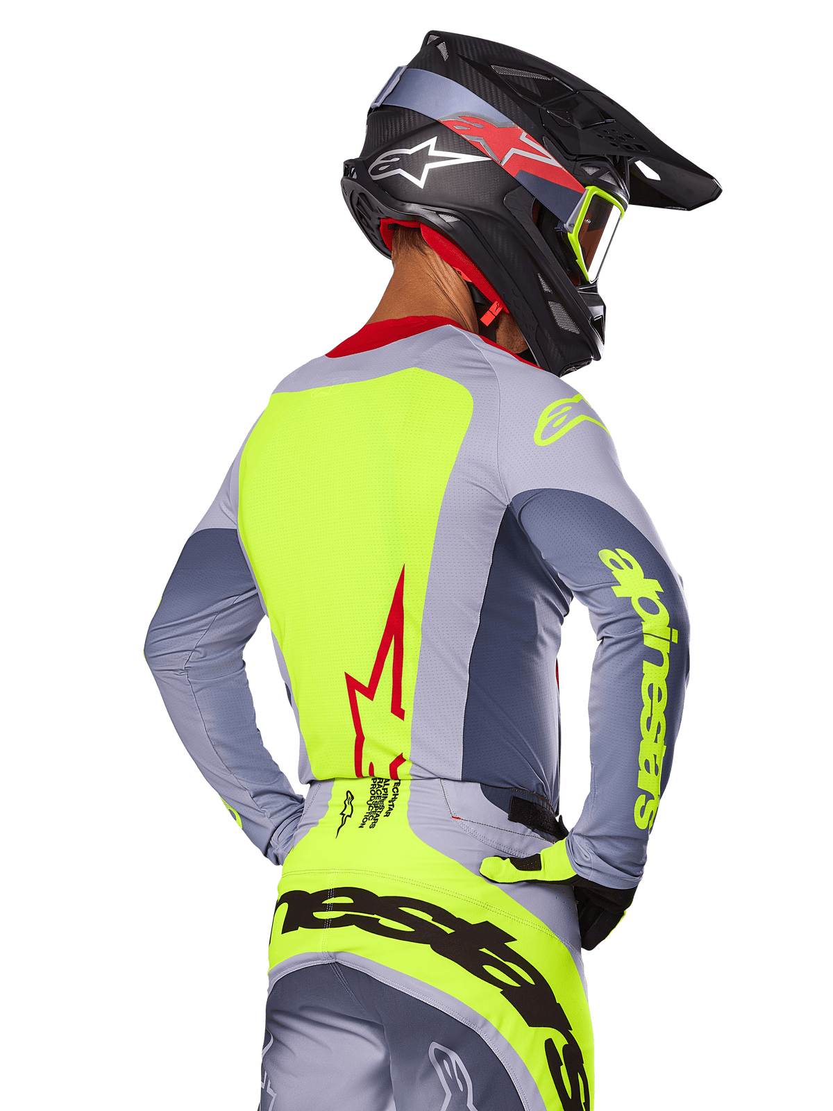 Alpinestars 2025 Techstar Melt Jersey, Bright Red Gray, achteraanzicht van motorcrossrijder in grijze en neongele race-uitrusting, rood sterlogo op de rug, bijpassende zwarte en rode helm, hoogwaardige off-road kleding