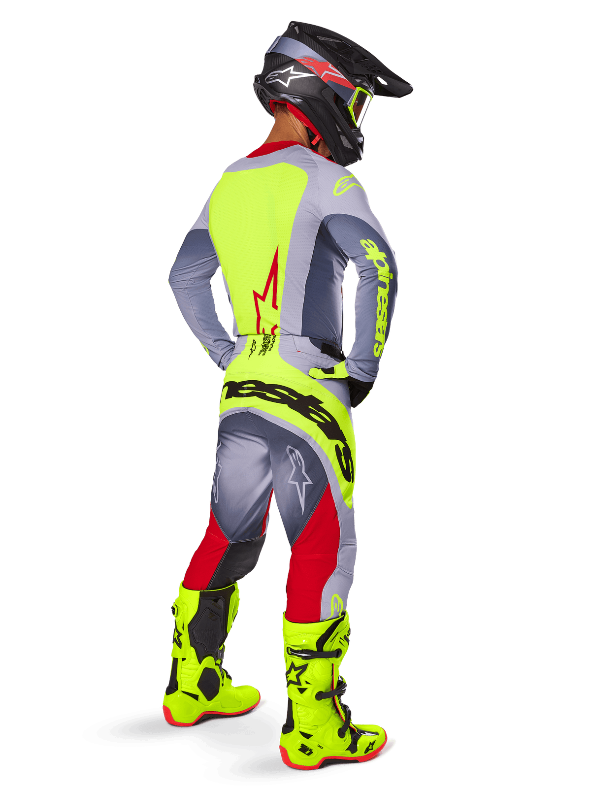 Alpinestars 2025 Techstar Melt Jersey in Bright Red Gray, motocrossrijder van achteren gezien met een felgeel rugpaneel en grijze mouwen, bijpassende grijze en rode broek met gele branding, felgele motorcrosslaarzen en een zwarte helm met gele goggles, complete off-road race-outfit