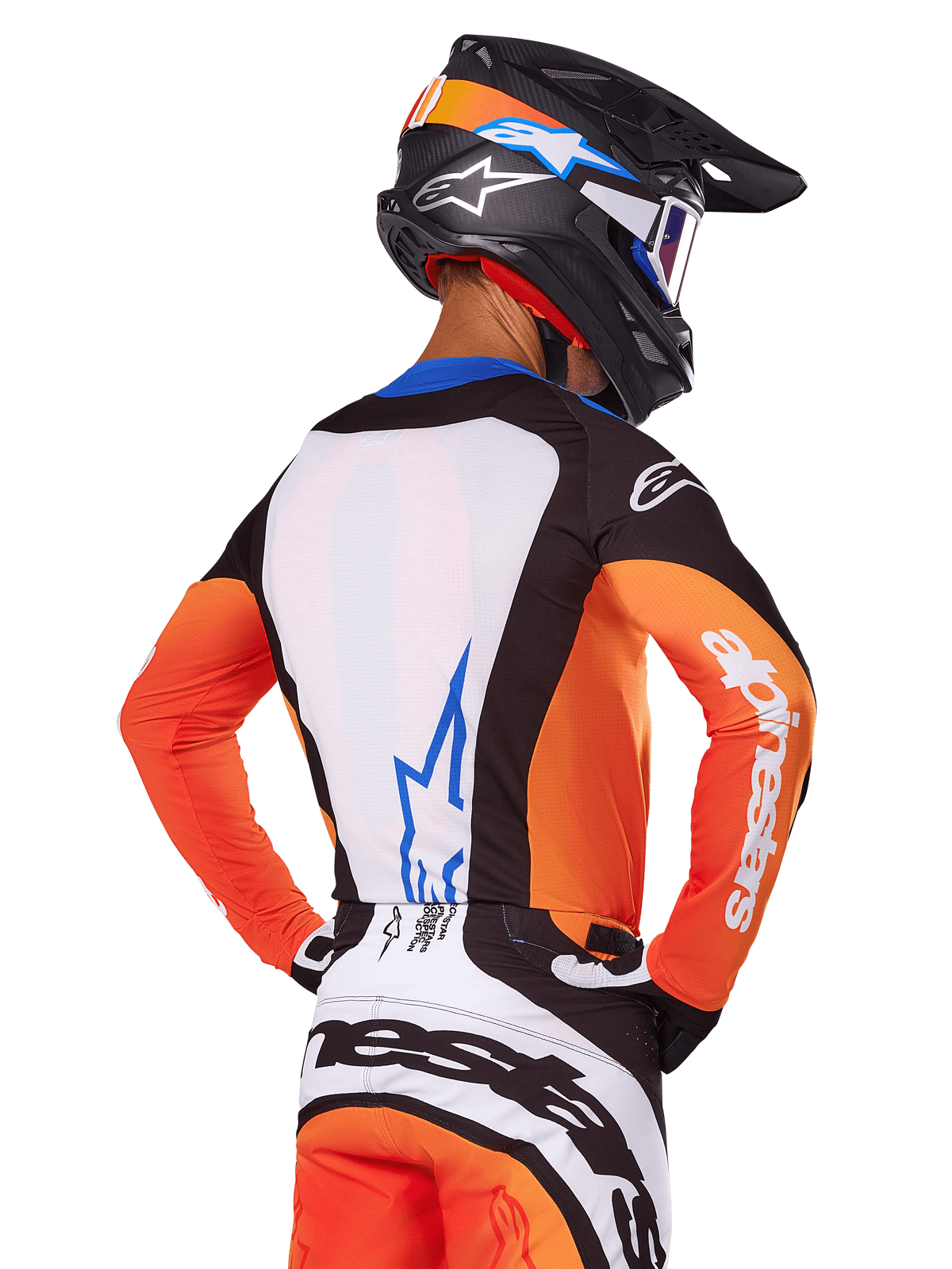 Pilote de motocross portant le maillot Alpinestars Techstar Melt 2025, orange et bleu, vue de dos montrant un panneau dorsal blanc avec logo bleu, manches oranges avec marquage blanc, casque et pantalon de motocross assortis, équipement de course professionnel