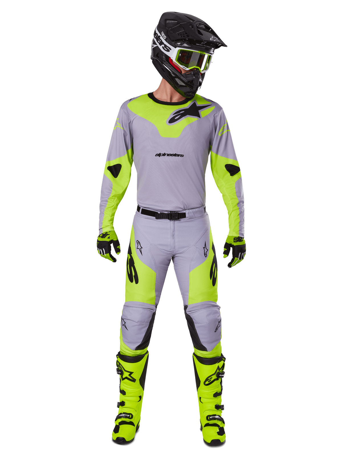 Motocross-Fahrer im Alpinestars 2025 Racer Veil Gear Set in Grau und Gelb Fluo, mit einem leichten Trikot und passender Hose, kombiniert mit einem schwarzen Helm, einer Fluo-Brille, Handschuhen und neongelben Stiefeln, komplette professionelle Offroad-Ausrüstung.