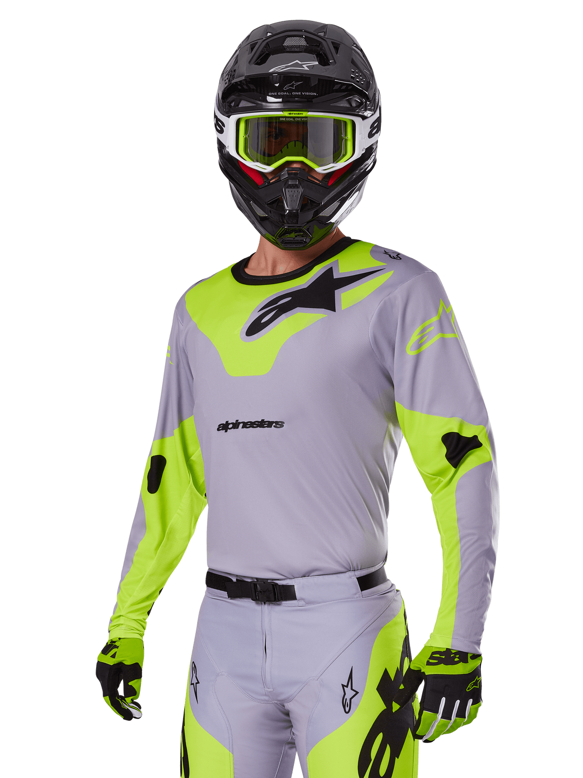 Motocross-Fahrer im Alpinestars 2025 Racer Veil Ausrüstungsset in Grau und Neongrün, hellgraues Trikot und Hose mit markanten neongelb-grünen Einsätzen und schwarzen Alpinestars-Logos, kombiniert mit passenden Handschuhen und einem schwarzen Helm mit neongrüner Brille, professionelle Offroad-Rennbekleidung.