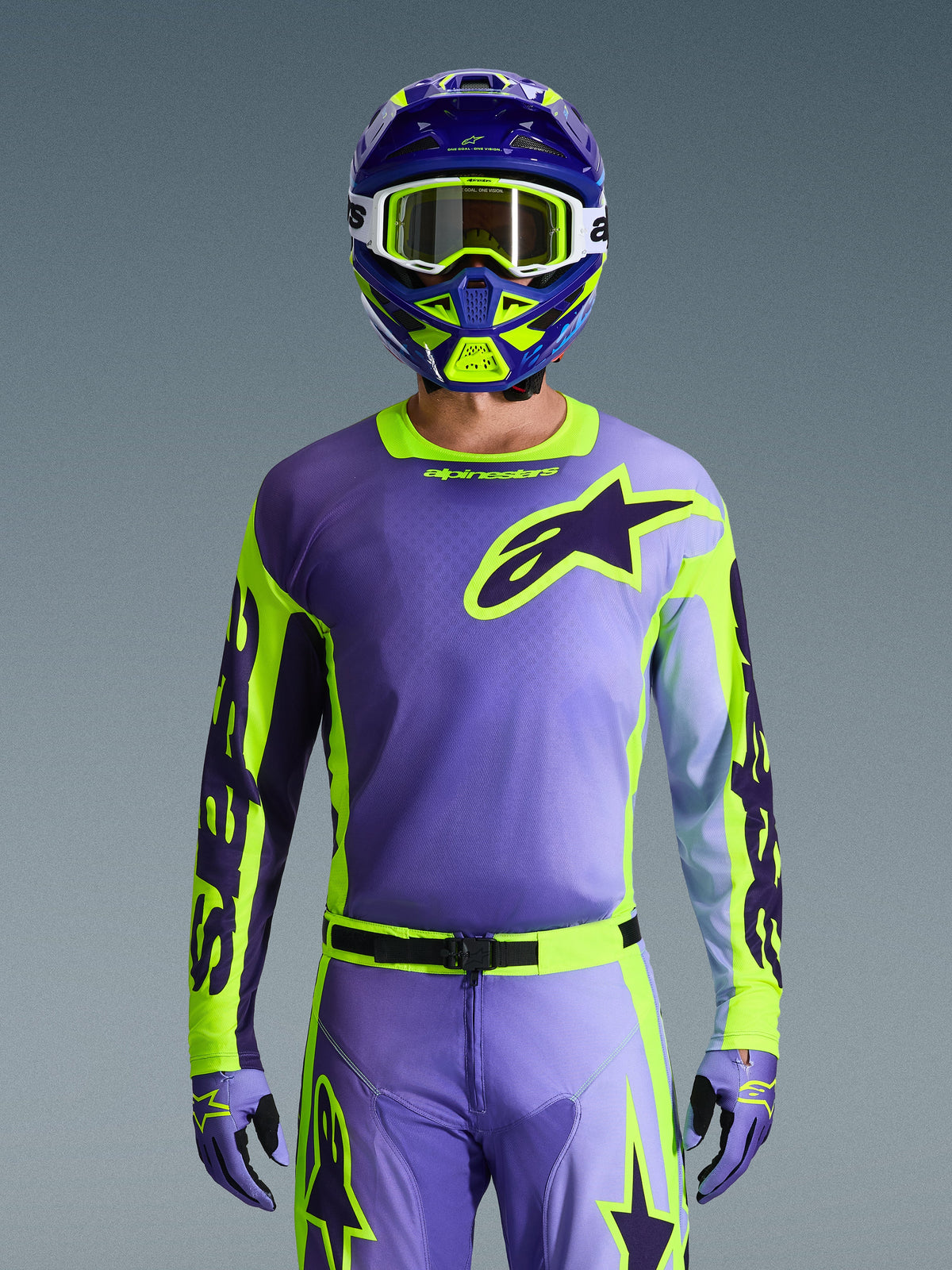 Ensemble d'équipement Alpinestars 2026 Racer Portl, tenue de motocross complète violet et vert citron, avec maillot violet aux manches jaune fluo et logo Astar violet foncé, casque assorti violet et vert avec lunettes blanches, pantalon et gants coordonnés pour la conduite tout-terrain.