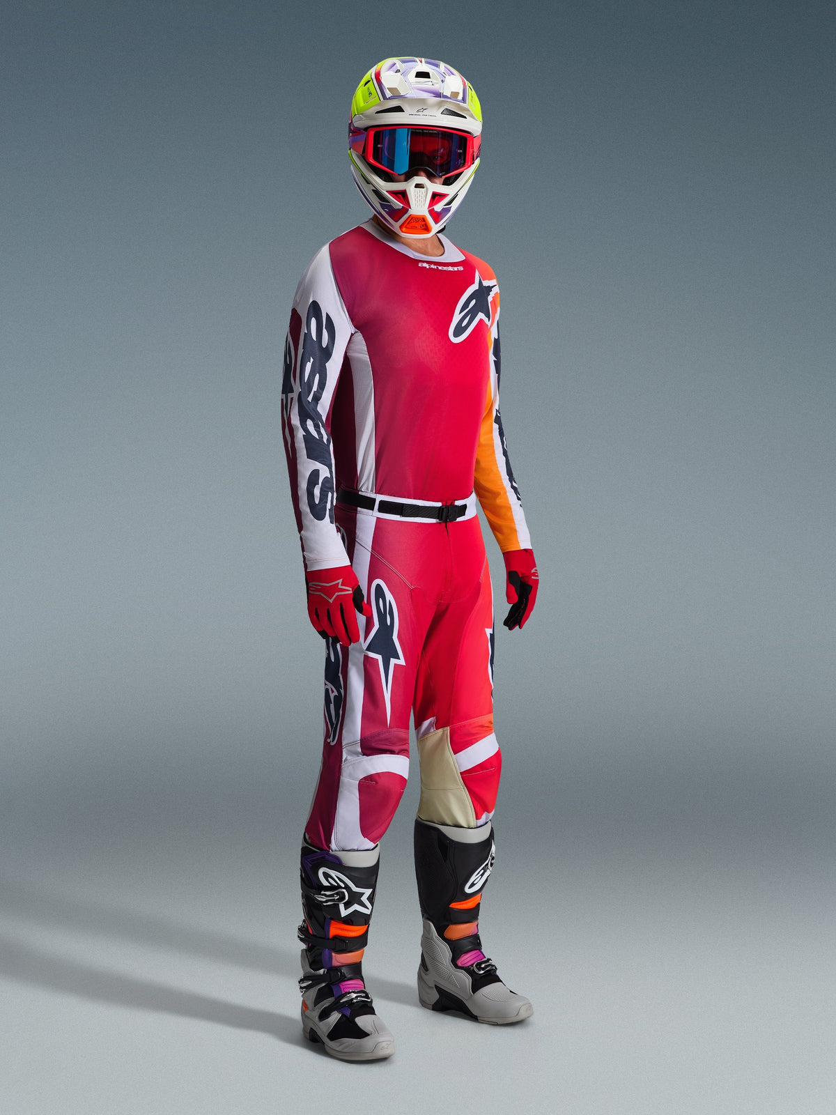 Motocross-Fahrer im Alpinestars 2026 Racer Portl Gear Set, mit rot-weißem Trikot und markantem 'Astars'-Branding am Ärmel, passender rot-weißer Hose, farblich abgestimmtem weiß-gelbem Helm mit rot gerahmter Brille und grau-schwarzen Motocross-Stiefeln, komplette Ausrüstung für den Offroad-Rennsport.