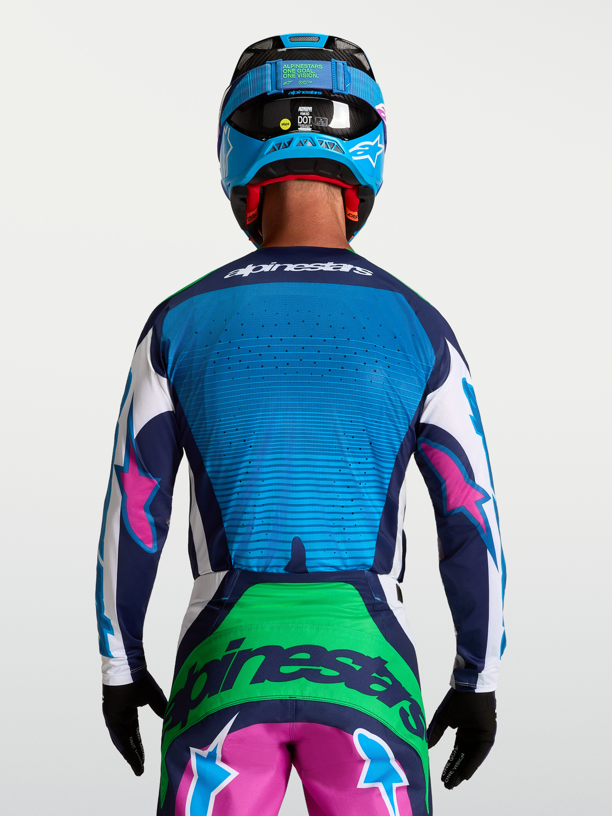 Maillot Alpinestars Techstar Maven, maillot de motocross pour homme, bleu et vert avec accents roses, vue de dos montrant les ventilations découpées au laser et le style racing.