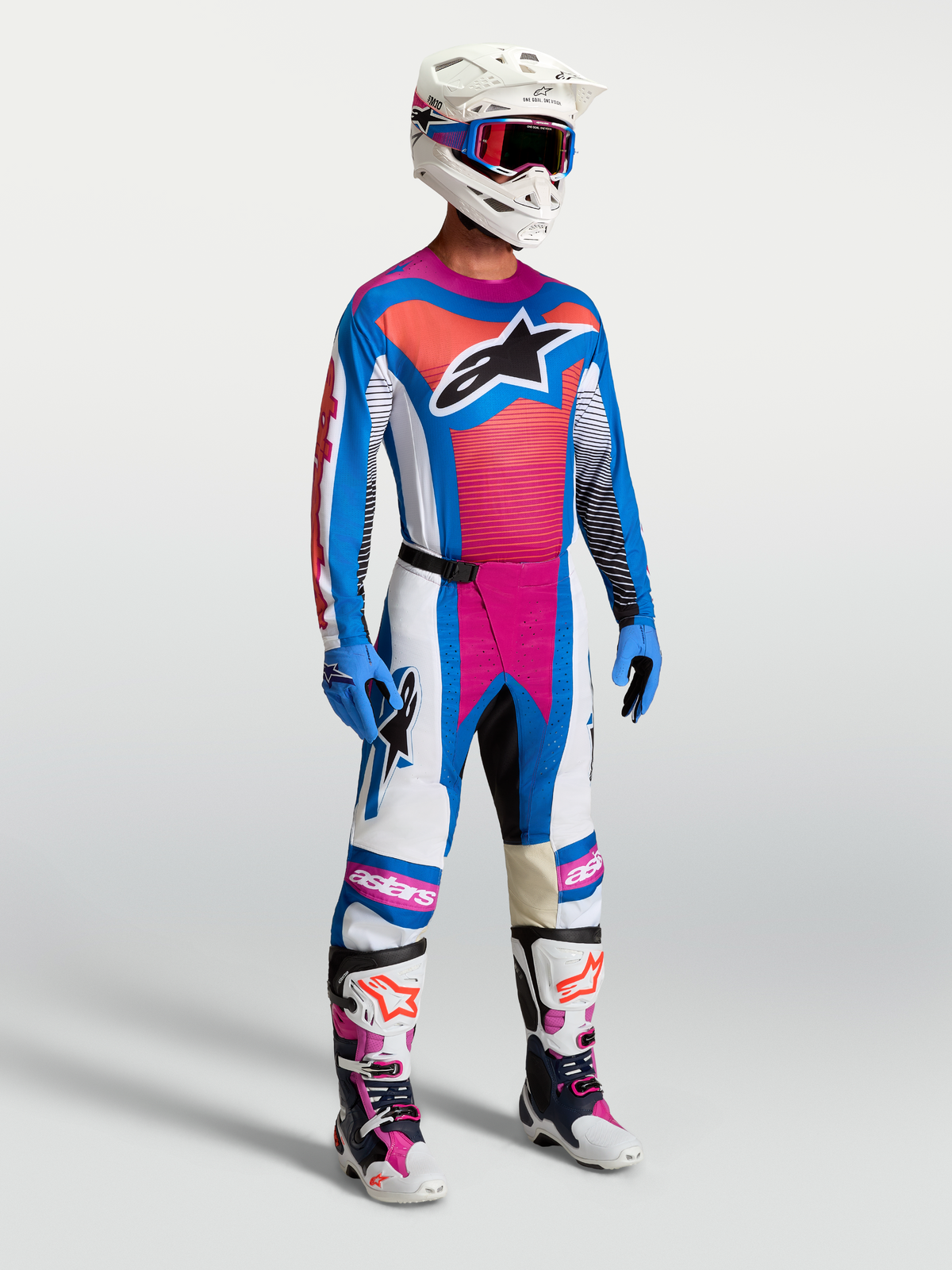 Maillot Techstar Maven et Techstar Maven Gear Set d'Alpinestars, tenue de motocross pour homme, bleu et corail, coupe athlétique, équipement tout-terrain porté par un pilote
