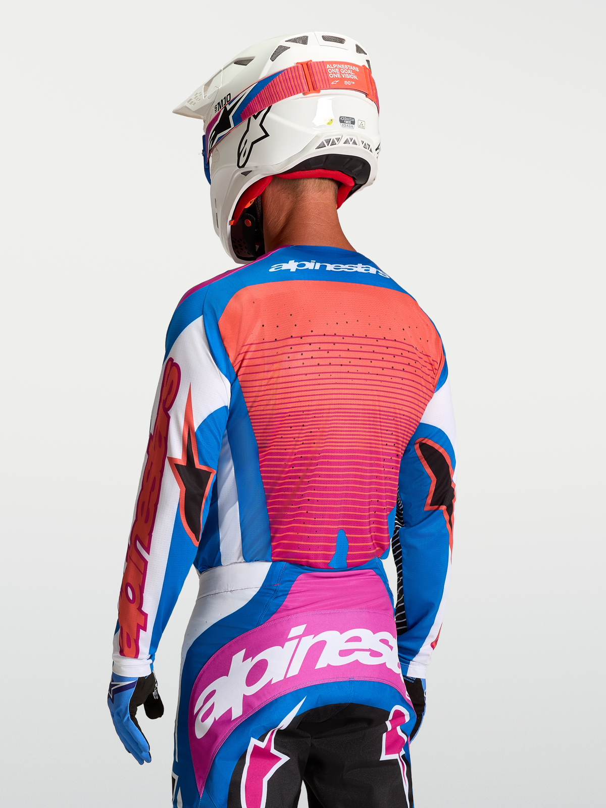 Alpinestars Maillot Techstar Maven, maillot de motocross pour homme, bleu et orange, aérations laser au dos, porté par un pilote avec casque