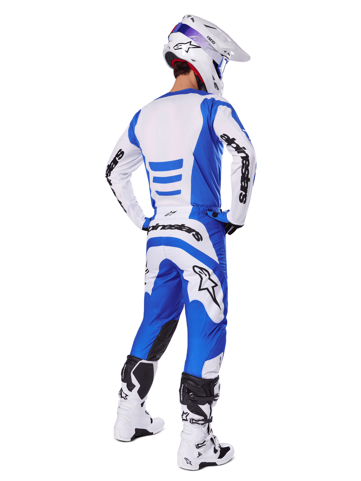 Motocross-Fahrer von hinten im Alpinestars 2025 Fluid Haul Gear Set, blau-weißes Trikot mit passender Hose, weißer Helm mit blauen Akzenten und weiß-schwarze Rennstiefel, koordiniertes Offroad-Rennoutfit