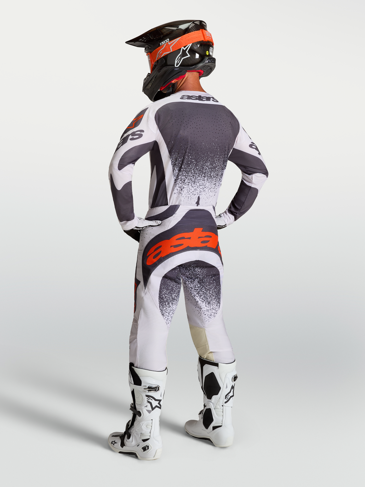 Maillot et Gear Set Alpinestars Techstar Swan, tenue de motocross pour homme, gris sombre et rouge fluo, vue de dos.