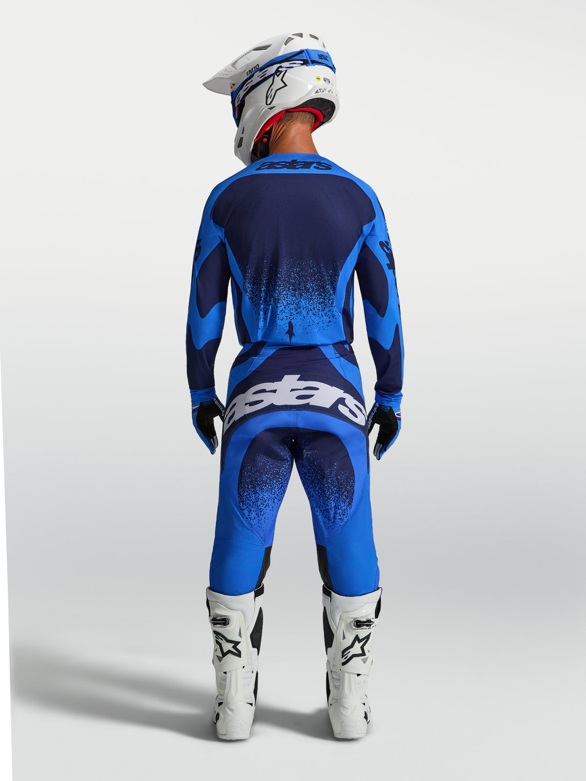 Alpinestars maillot Techstar Swan et ensemble motocross 2027, bleu et bleu marine pour homme, vue de dos, bottes blanches.