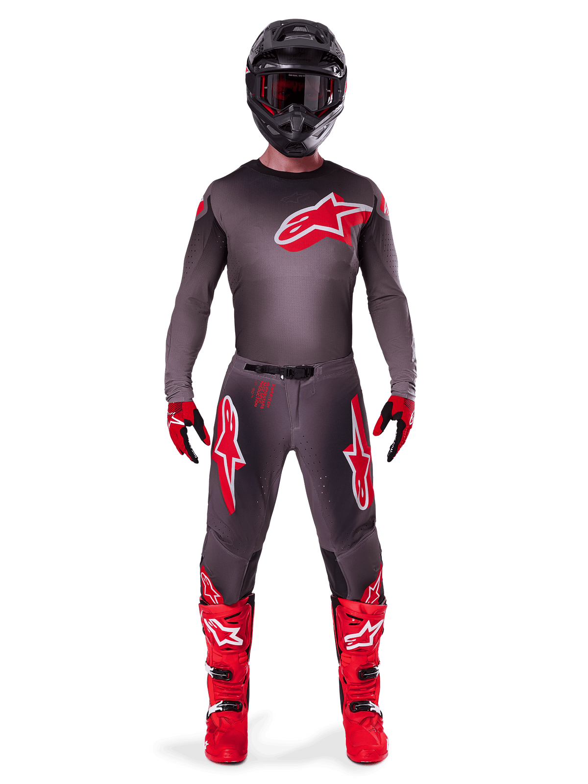 Motorcrosser in Alpinestars 2025 Supertech Lipan Gear Set, Smoke en Bright Red, donkergrijze jersey en broek met opvallende rode Alpinestars-logo's, felrode laarzen, zwarte helm en rode handschoenen, gecoördineerde professionele outfit voor off-road racing