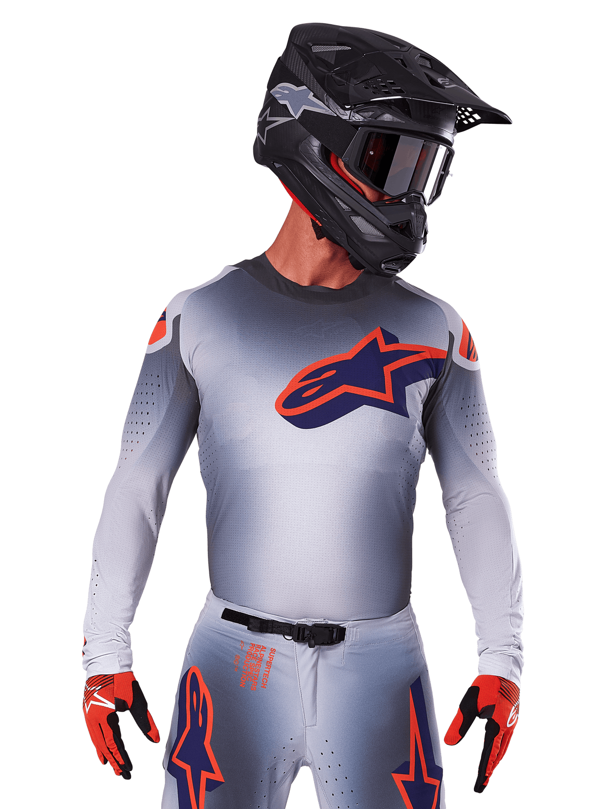 2025 Supertech Lipan Trikot, Motocross-Renntrikot, Grau mit Akzenten in Orange und Marineblau, langärmeliges Performance-Oberteil mit perforierten Belüftungsdetails, getragen mit schwarzem Helm und roten Handschuhen, schnittiges Racing-Design