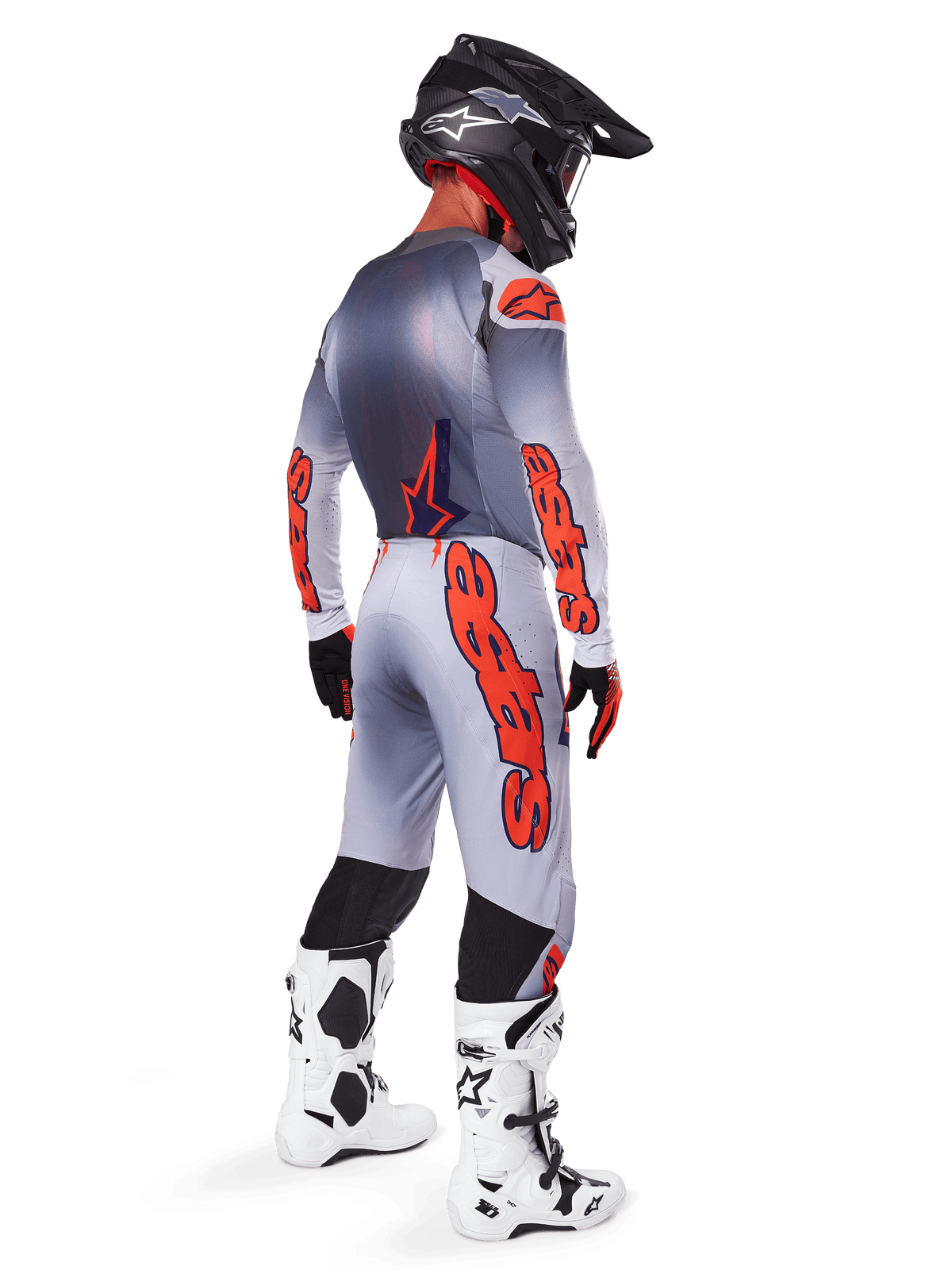 Motocross-Fahrer von hinten im 2025 Supertech Lipan Gear Set, Trikot in Grau und Orange Fluo mit passender Hose, markantes orangefarbenes Alpinestars-Branding auf Ärmeln und Beinen, schwarzer Helm, weiß-schwarze Motocross-Stiefel, professionelles Offroad-Rennoutfit.