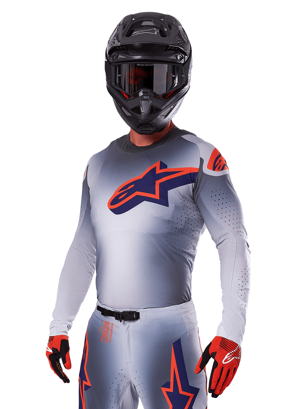 Motocross-Fahrer im Alpinestars 2025 Supertech Lipan Ausrüstungsset, graues Trikot und Hose mit navyblauen und orangefarbenen Akzenten, mattschwarzer Helm mit Brille, rote und schwarze Handschuhe, sportliche Performance-Ausrüstung für Offroad-Rennsport