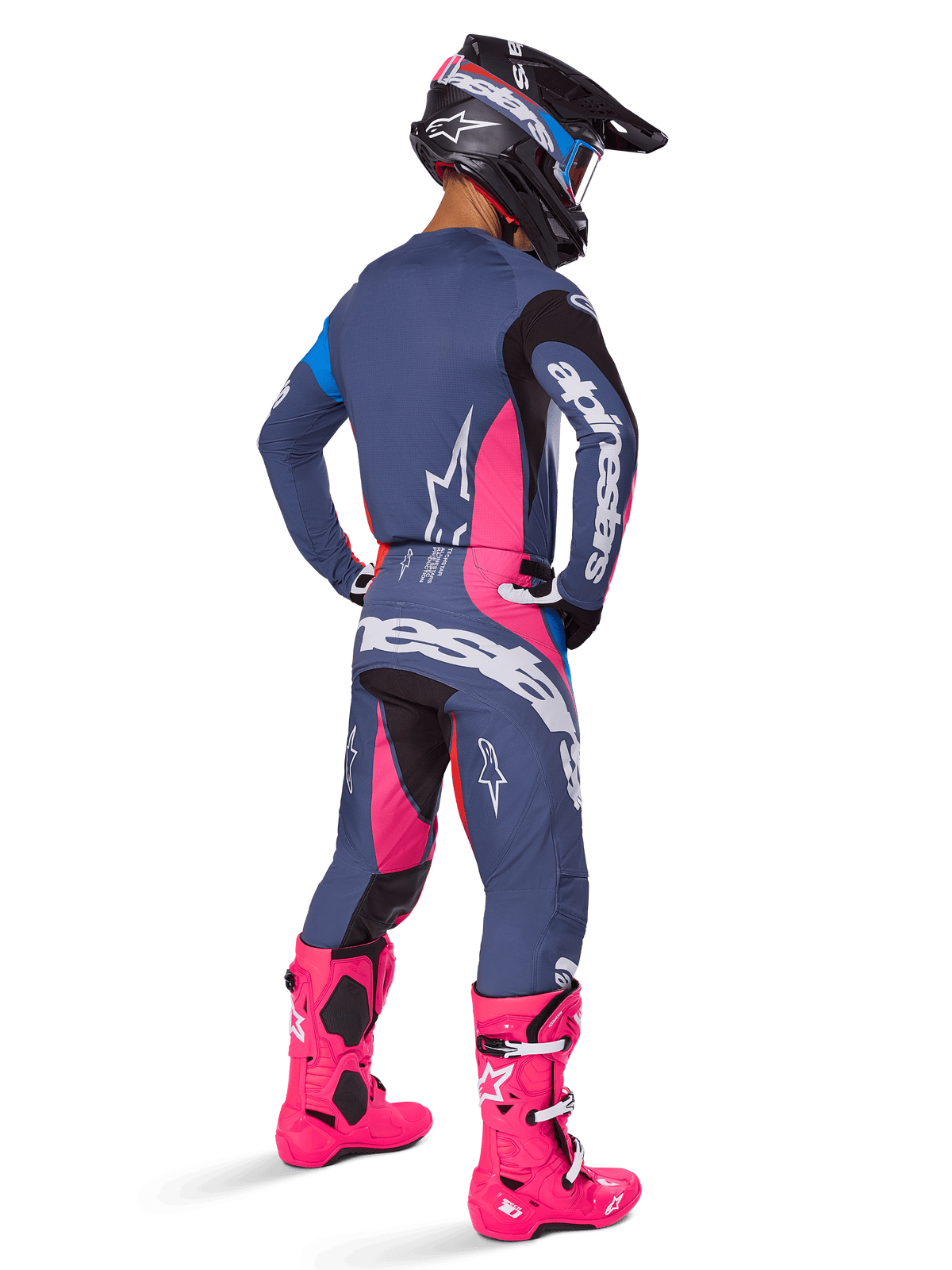 Motocross-Fahrer in der Rückansicht, trägt das Alpinestars 2025 Techstar Dreem Gear Set, Grau mit leuchtend pinken und weißen Akzenten, schwarz-weißer Helm und leuchtend pinke Stiefel, komplette Rennausrüstung für Motocross-Performance.